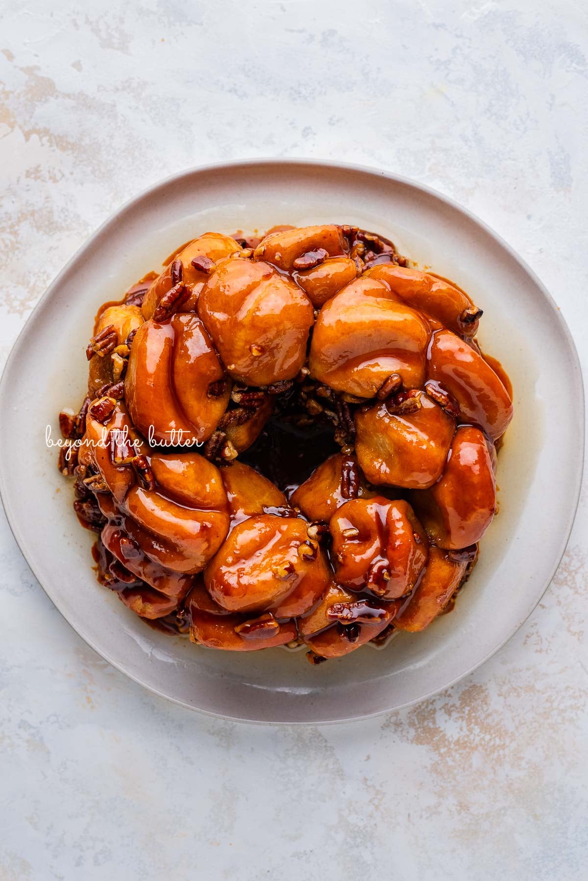 5 ingredient butterscotch bundt rolls on a white dessert plate and white background | © Luyiz®