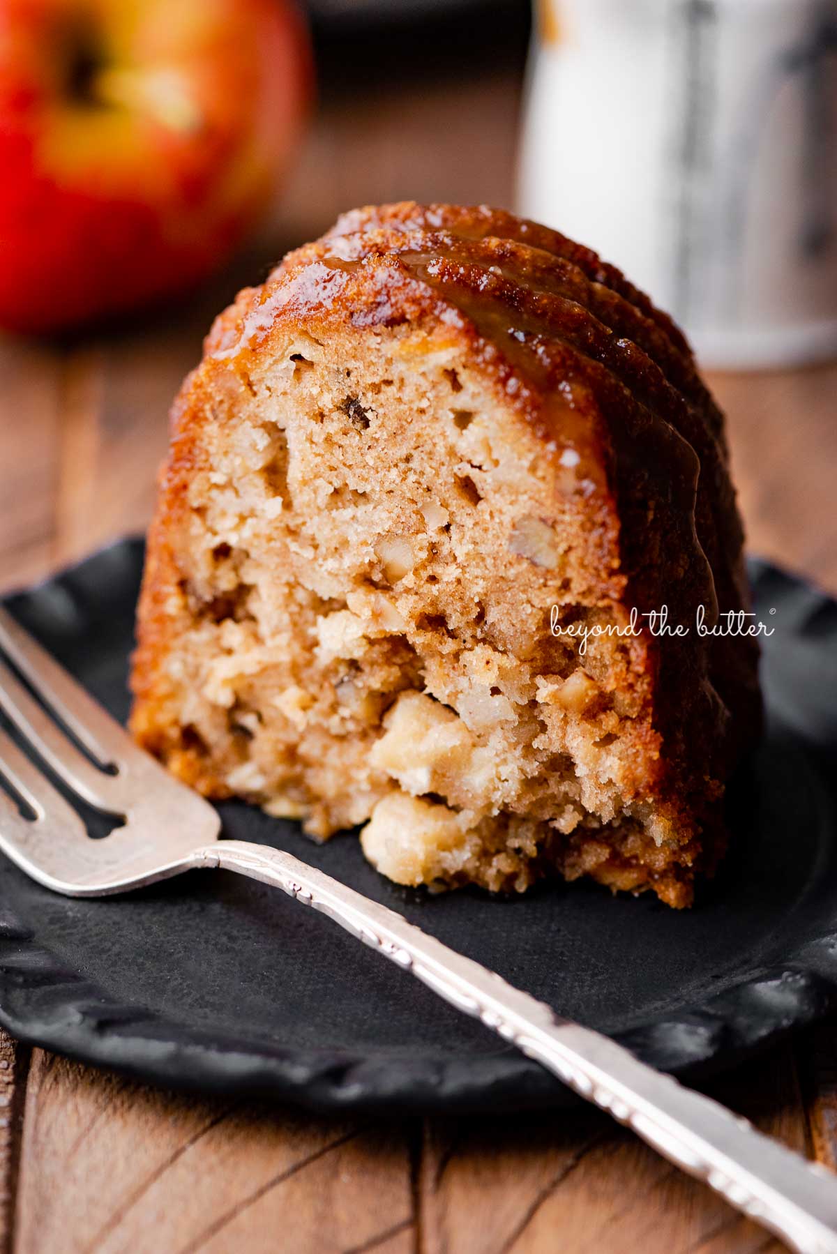 Slice of homemade apple bundt cake on dark wood background | © Luyiz®