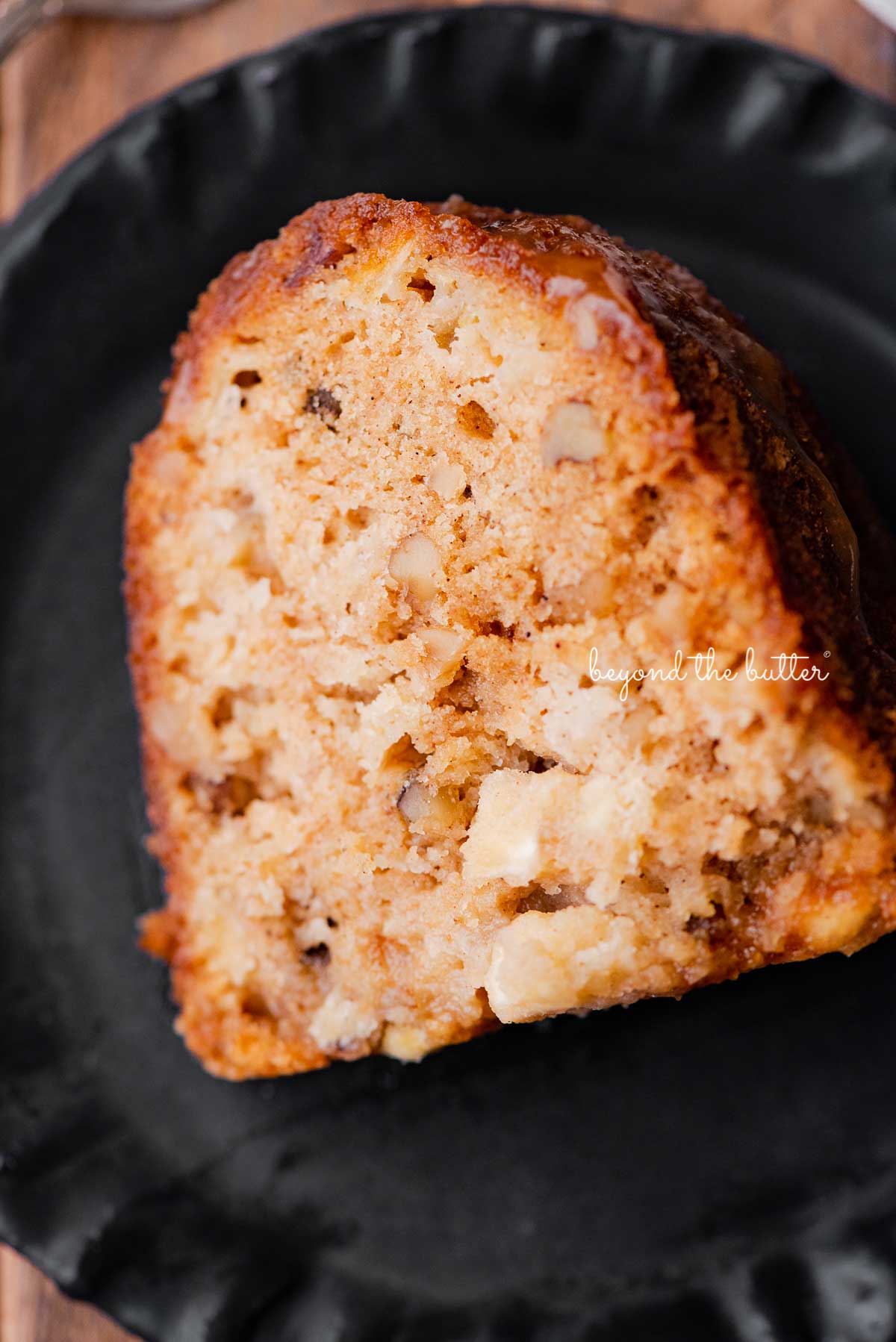 Slice of homemade apple bundt cake on dark wood background | © Luyiz®