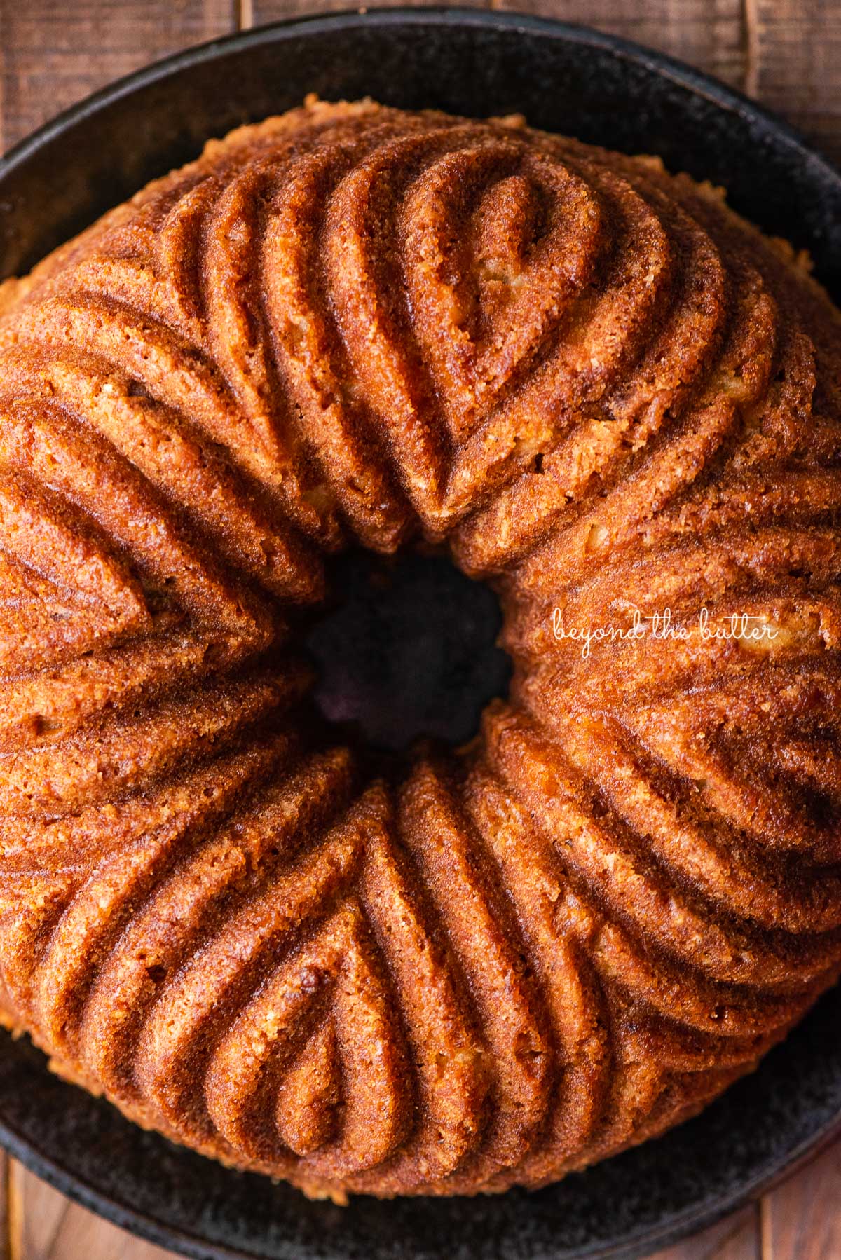 Homemade apple bundt cake on black ceramic plate and dark wood background | © Luyiz®