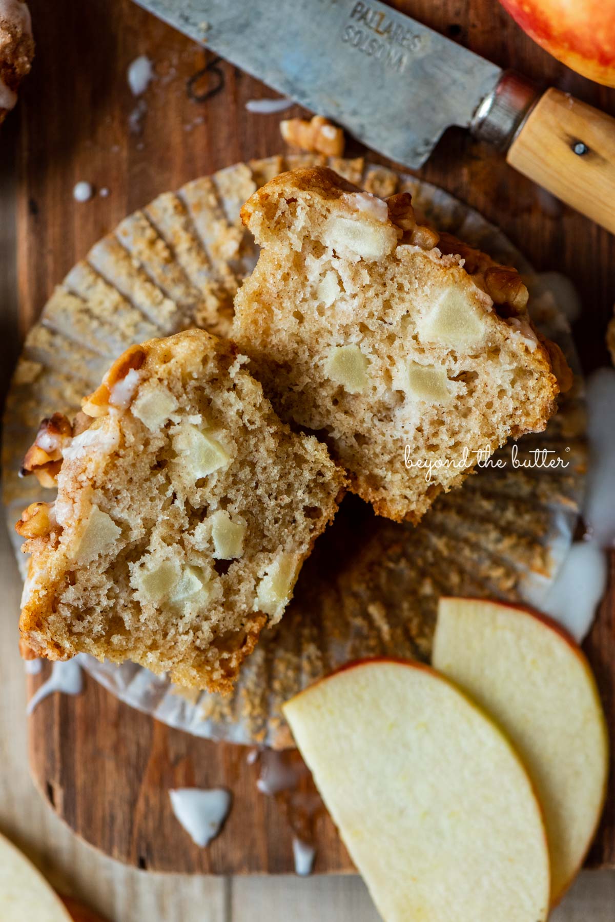 Sliced apple cinnamon streusel muffin on a wood cutting board with sliced apples | © Luyiz®