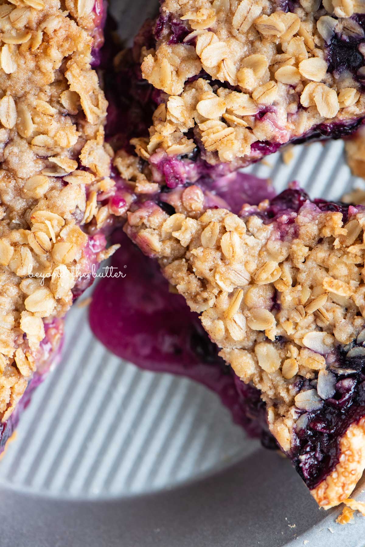 Slices of blueberry crumble pie in pie plate with scoopy of ice cream in the center | © Luyiz®