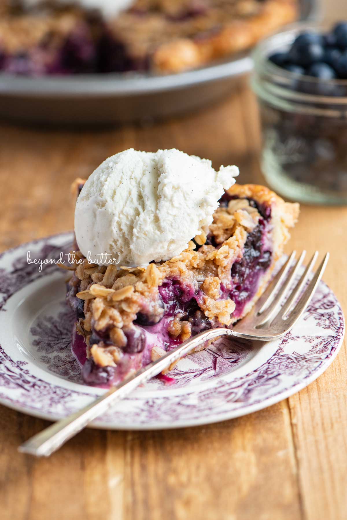 Slice of blueberry crumble pie with scoop of vanilla bean ice cream on top | © Luyiz®