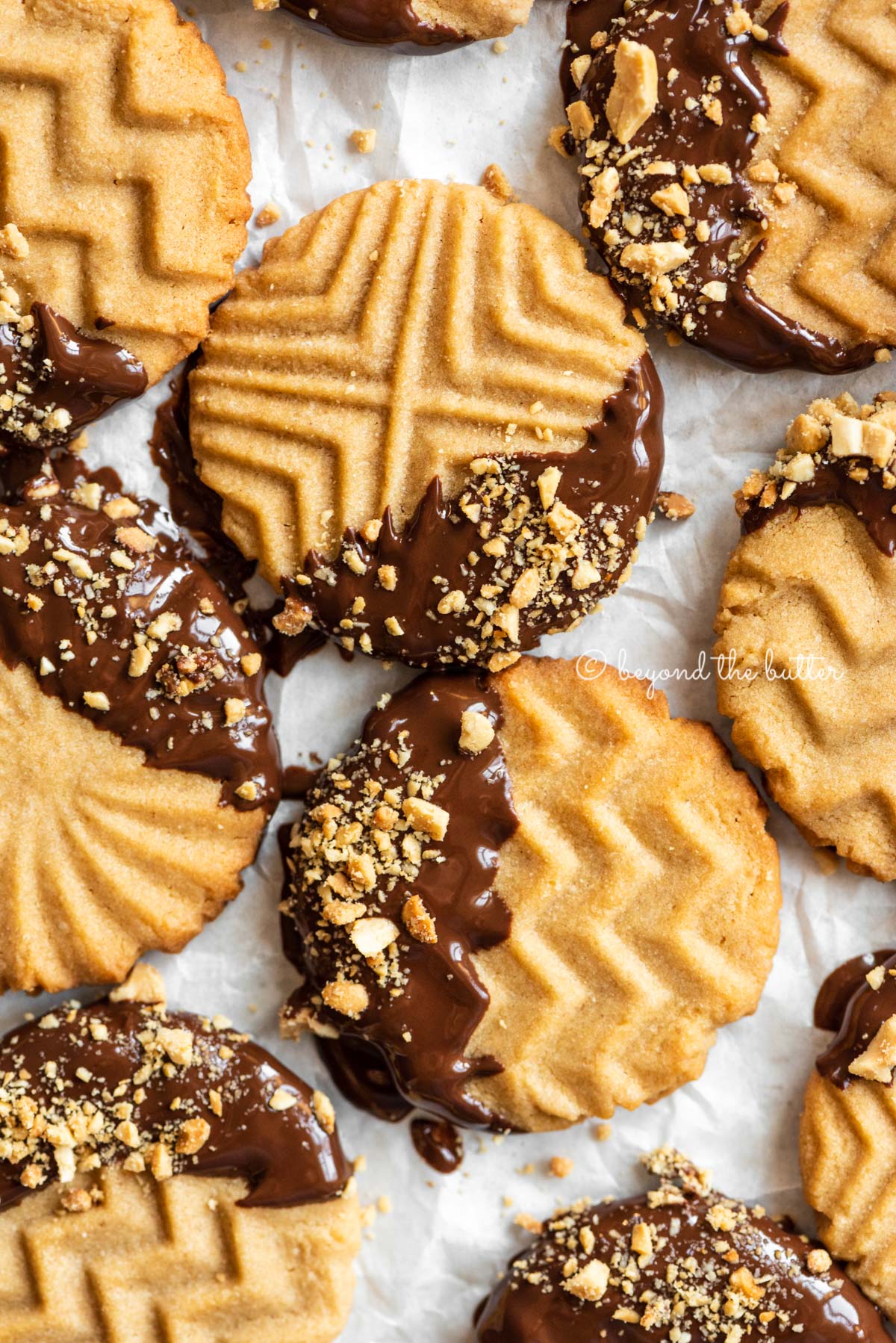 Baking sheet with randomly placed chocolate dipped peanut butter cookies | All Images © Luyiz®