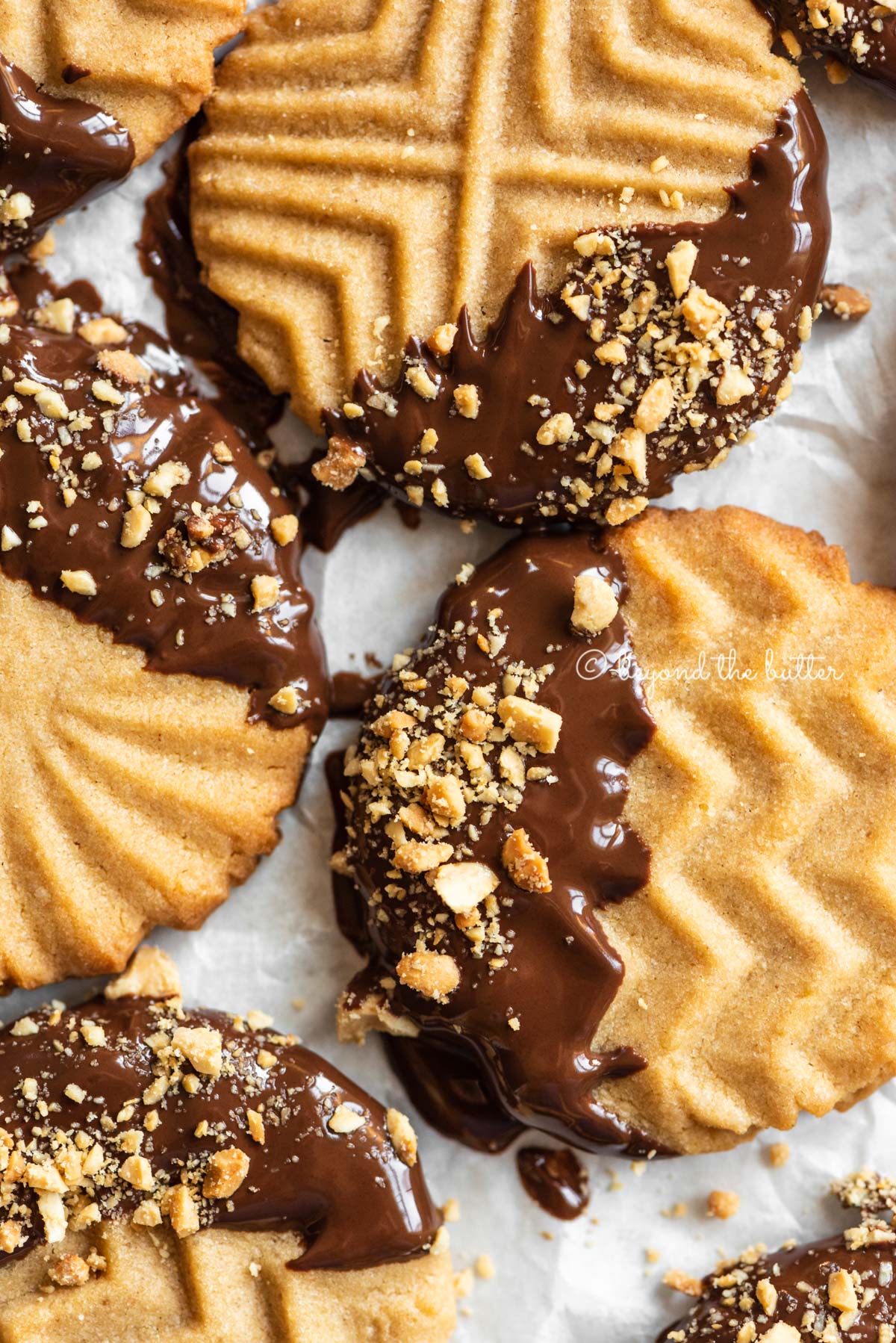 Baking sheet with randomly placed chocolate dipped peanut butter cookies | All Images © Luyiz®