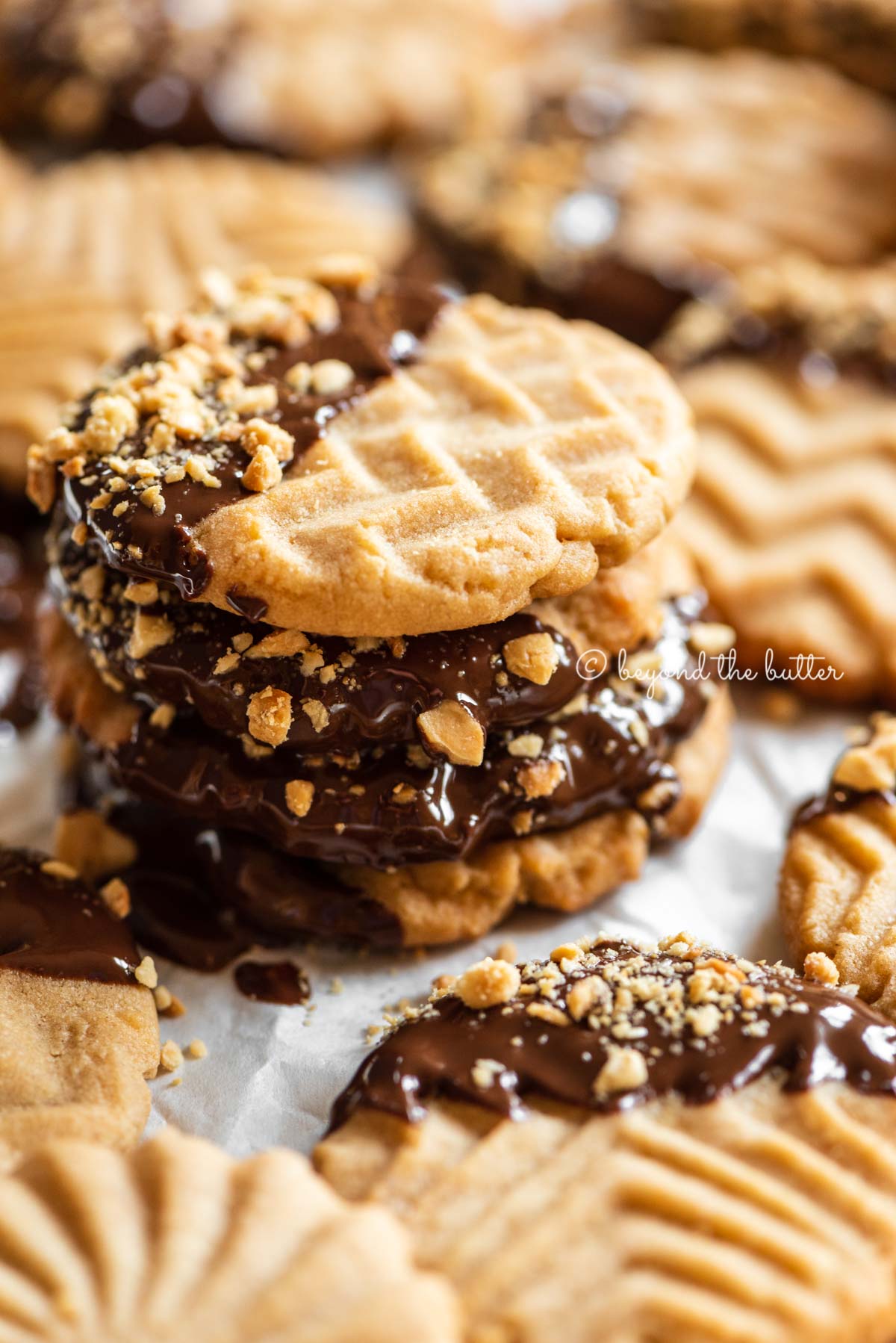 Baking sheet with randomly placed and stacked chocolate dipped peanut butter cookies | All Images © Luyiz®