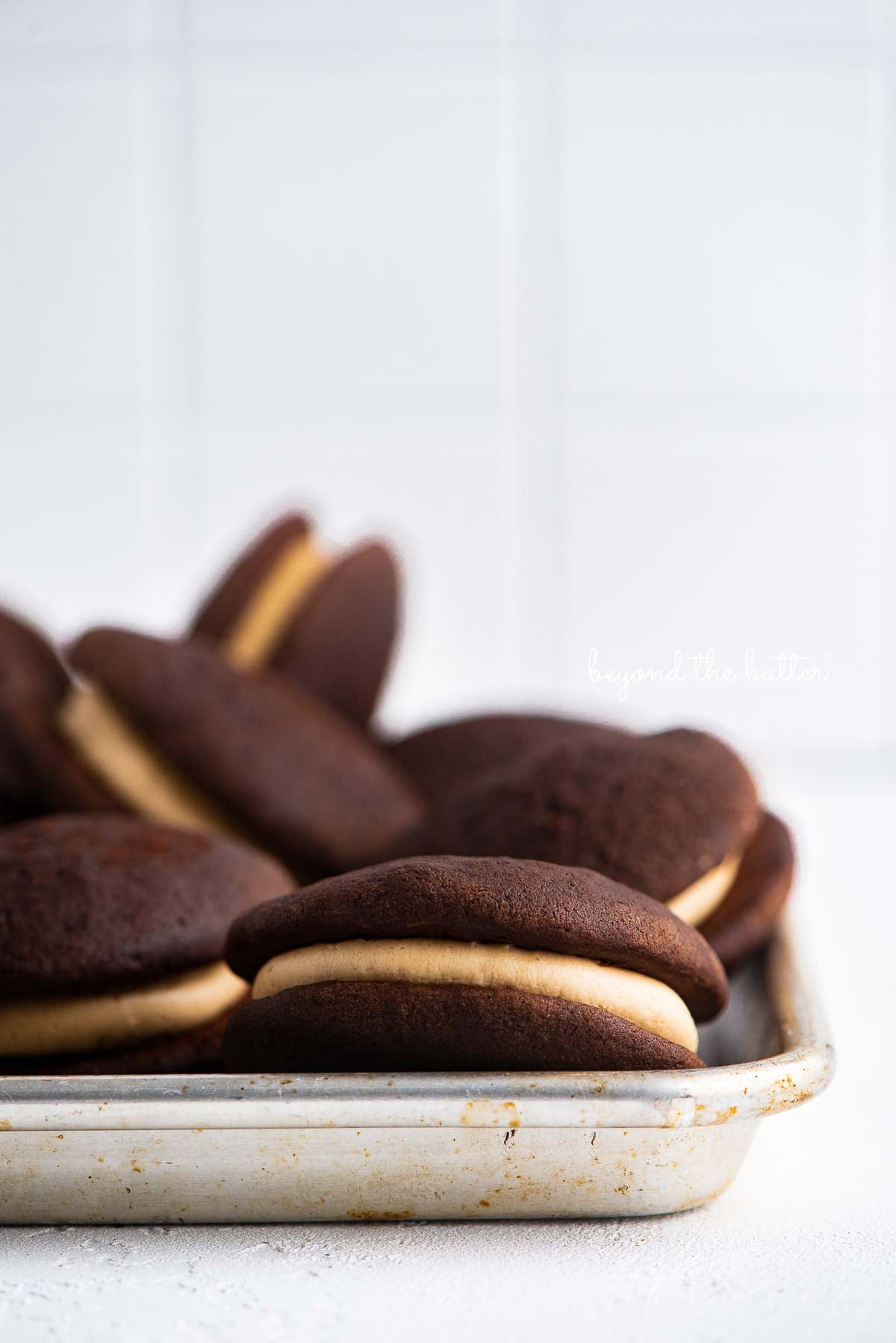 Chocolate peanut butter whoopie pies on a parchment lined baking pan | © Luyiz®