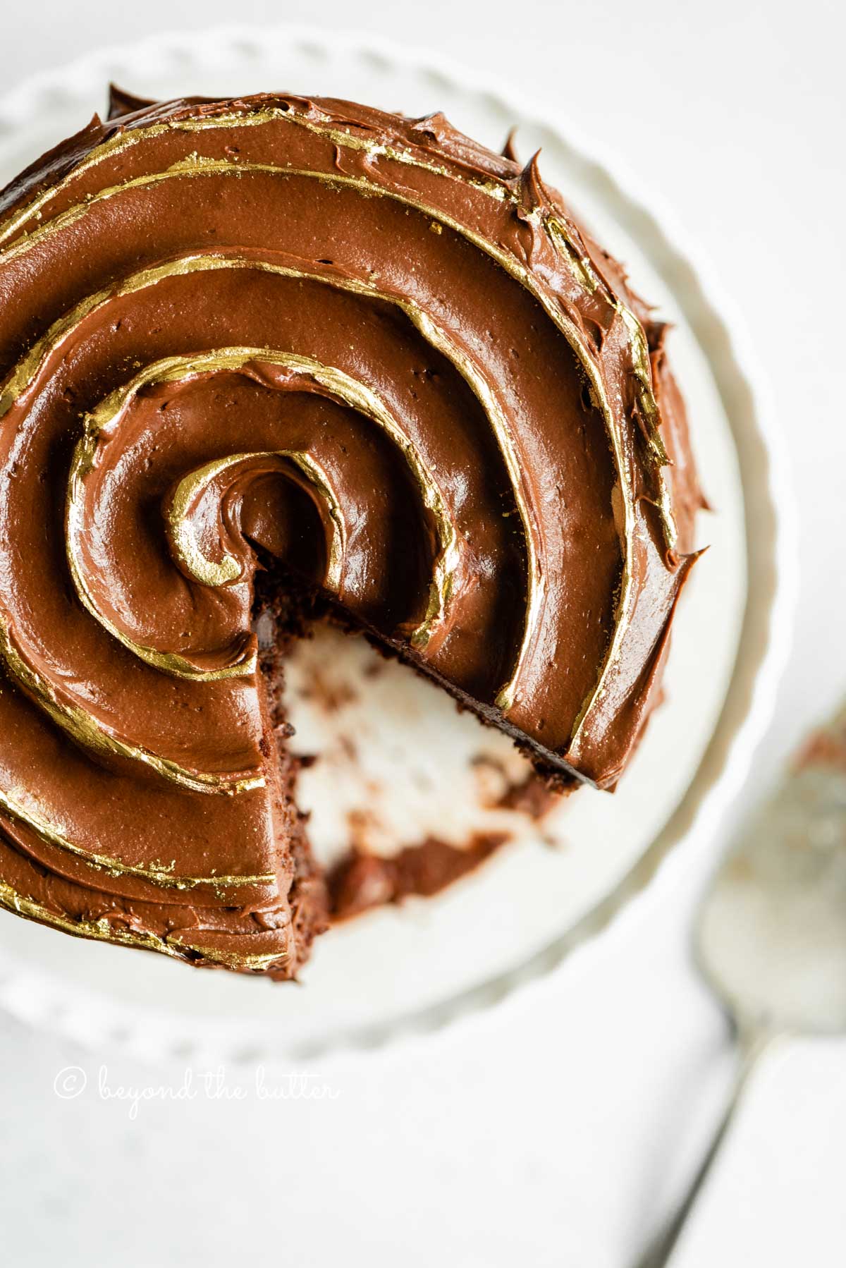 Overhead image of chocolate zucchini cake with chocolate chip with a slice removed | All Images © Luyiz™