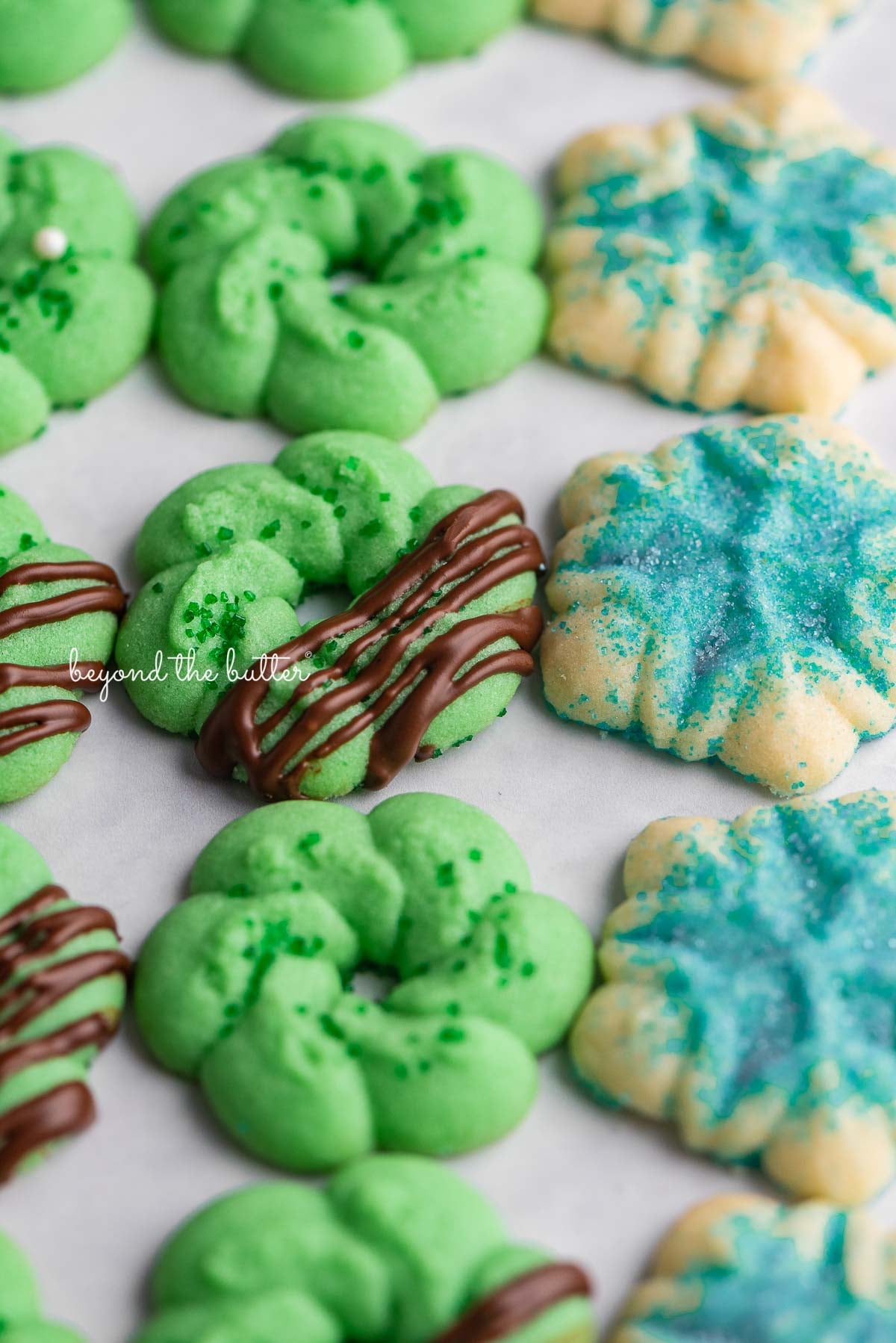 Decorated classic buttery spritz cookies lined up on a white marbled background | © Luyiz®