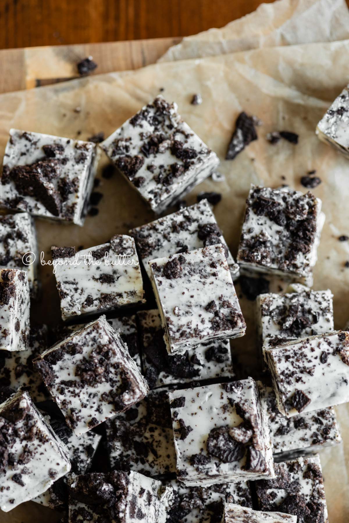 Pieces of cookies and cream fudge randomly placed on top of brown parchment paper | All Images © Luyiz®