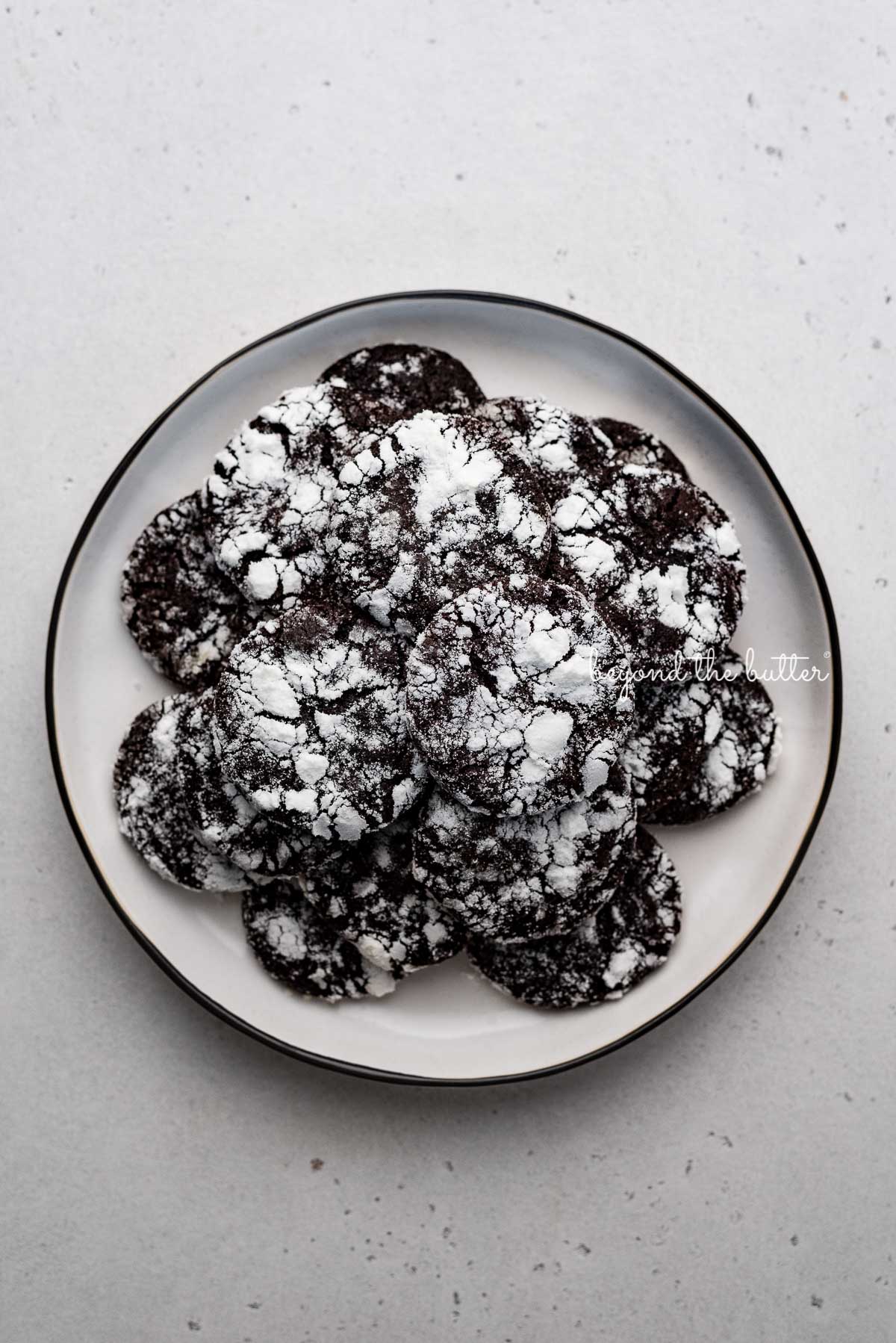 Dessert plate of dark chocolate crinkle cookies on light gray background | © Luyiz®