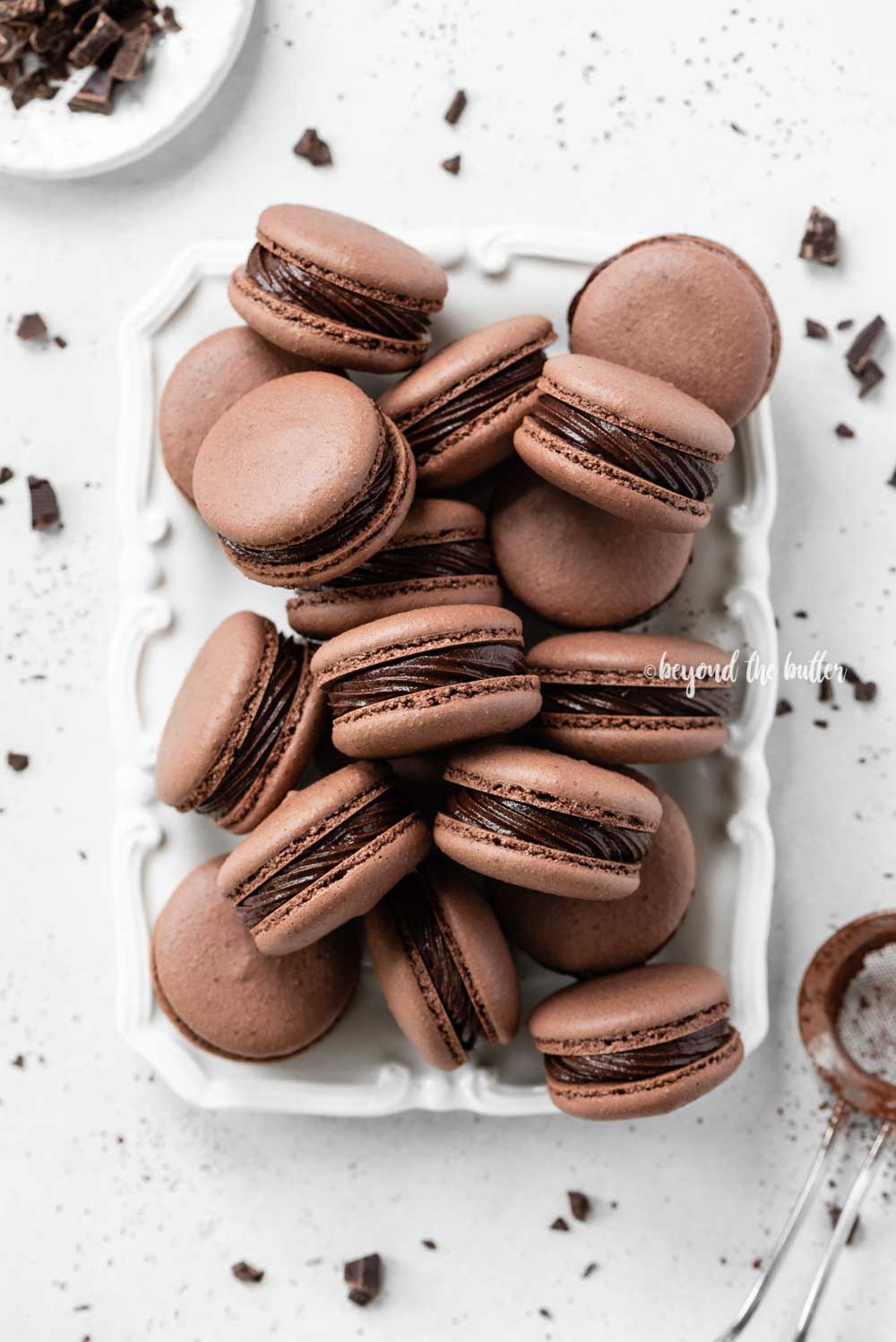 Plate full of dark chocolate macarons | All Images © Luyiz™