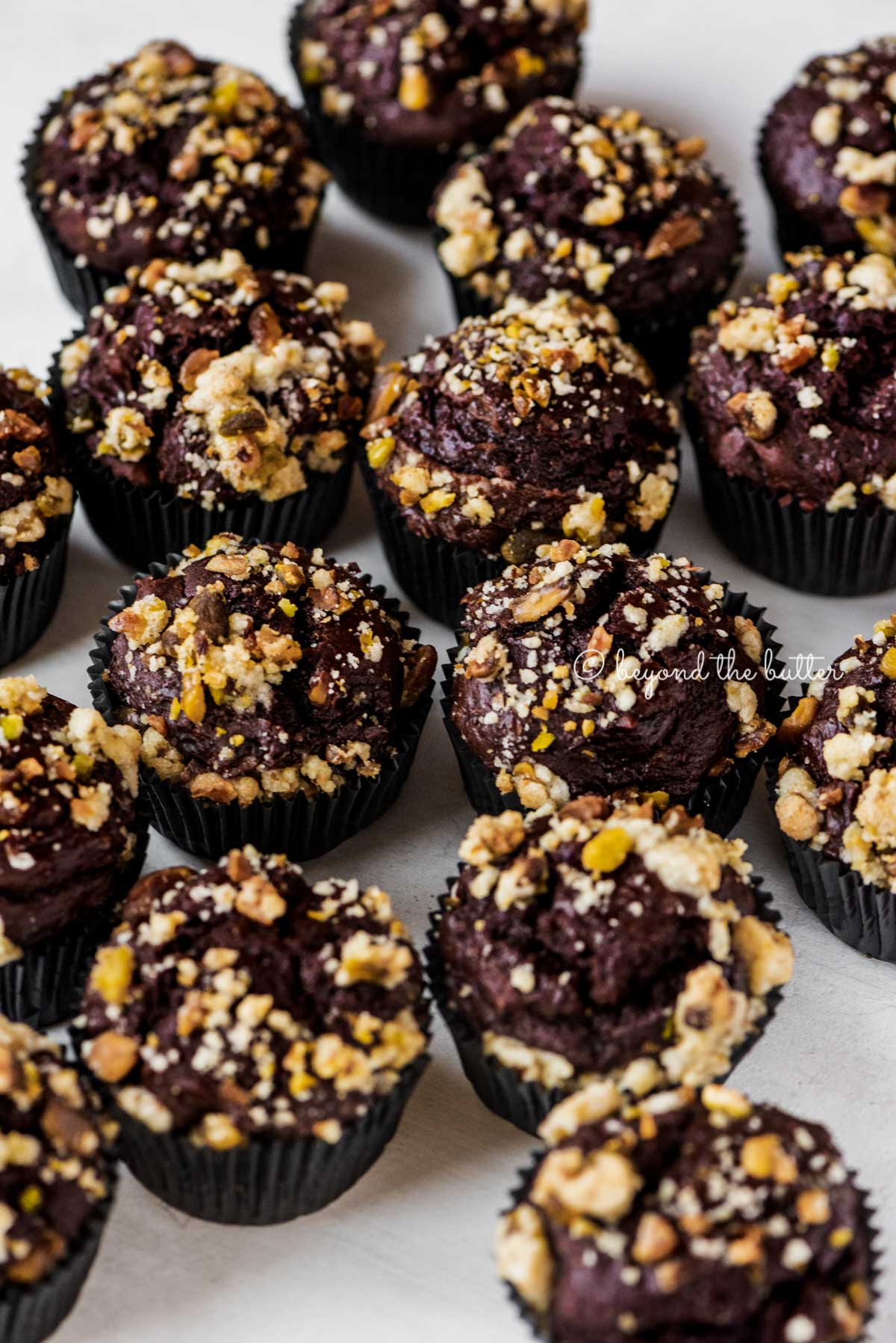 Randomly places dark chocolate pistachio cream cheese muffins on gray background | All Images © Luyiz®