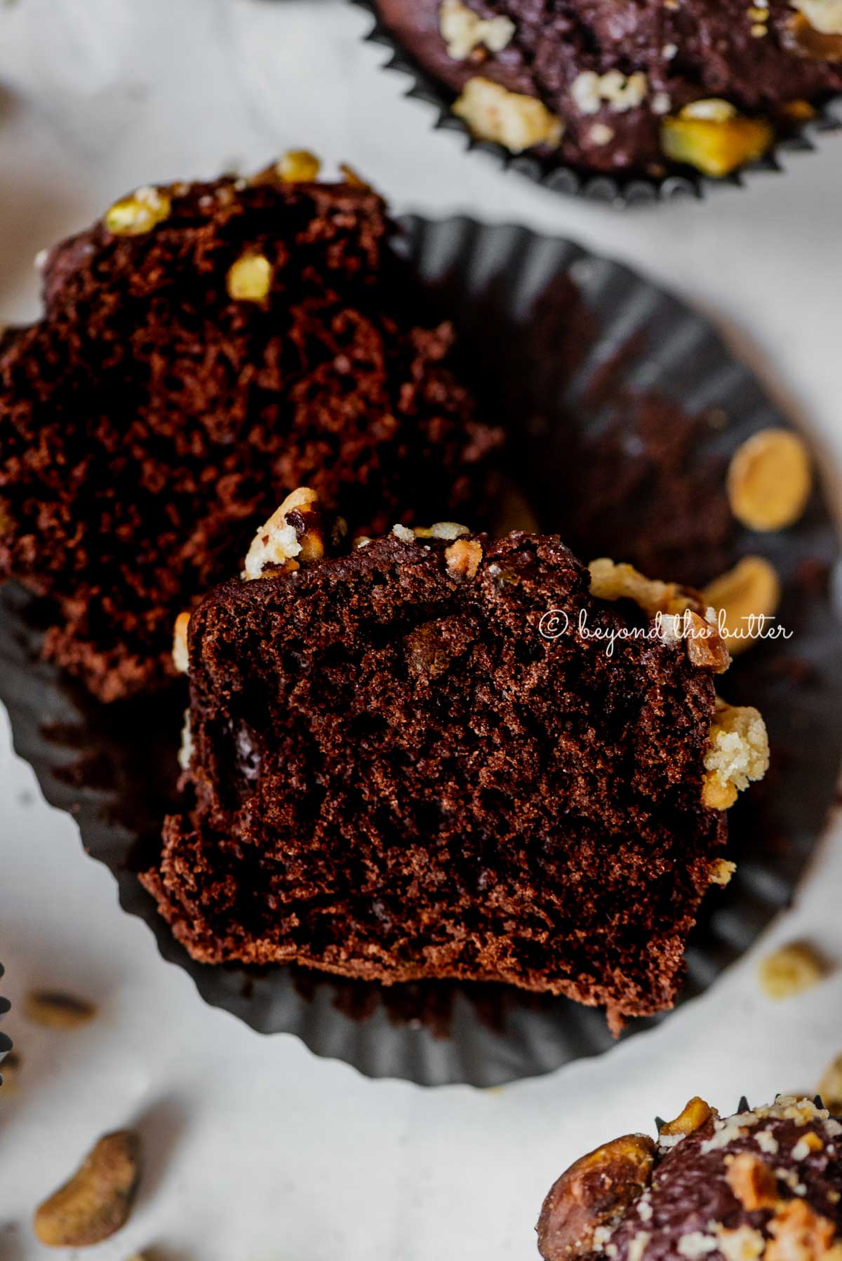 Dark chocolate pistachio cream cheese muffins with center muffin unwrapped and cut in half | All Images © Luyiz™