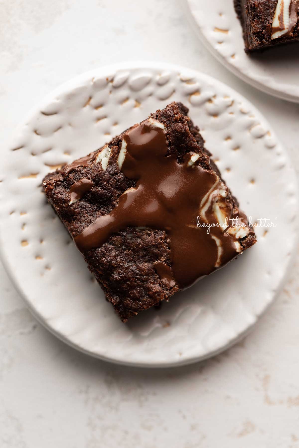 A single mint chocolate brownie on a small white dessert plate | © Luyiz®