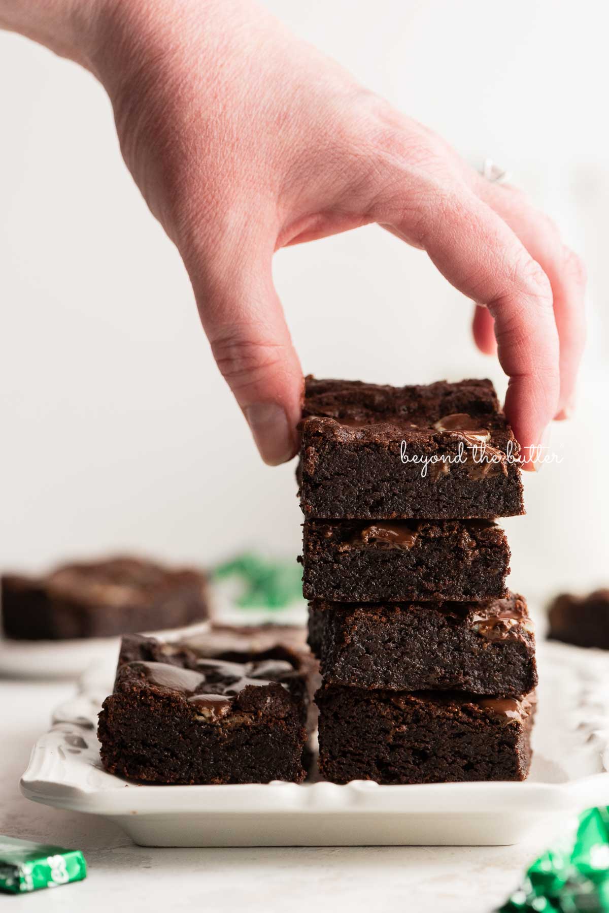 Stacking mint chocolate brownies on a white dessert plate | © Luyiz®