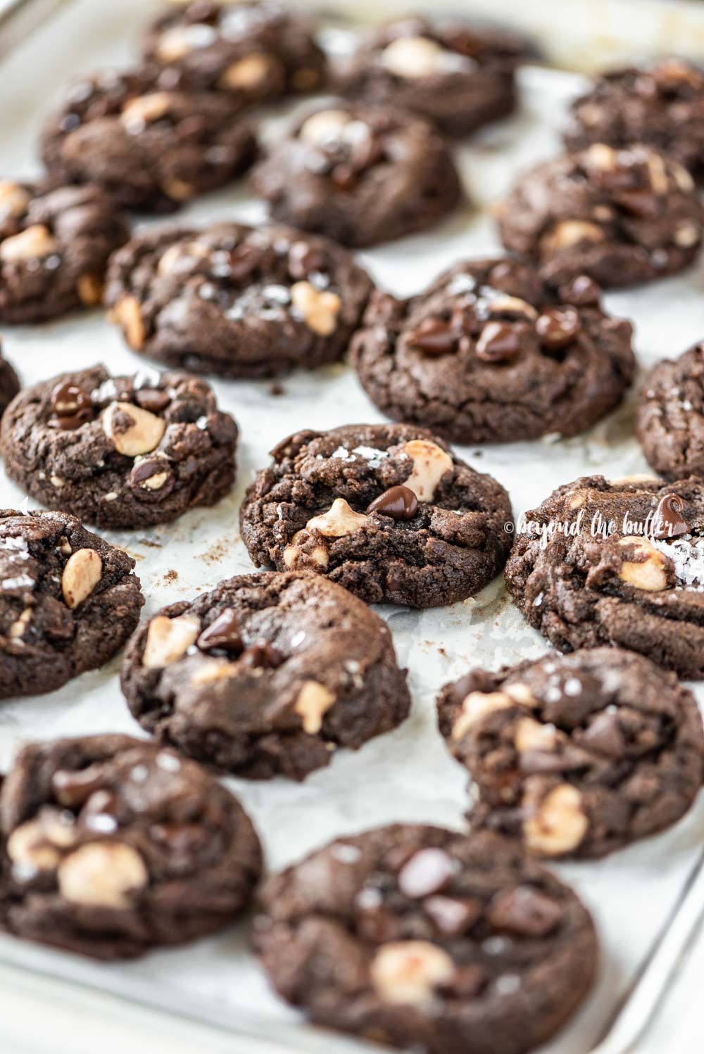 Angled image of just baked double chocolate salted caramel cookies on a baking sheet | All Images © Luyiz™