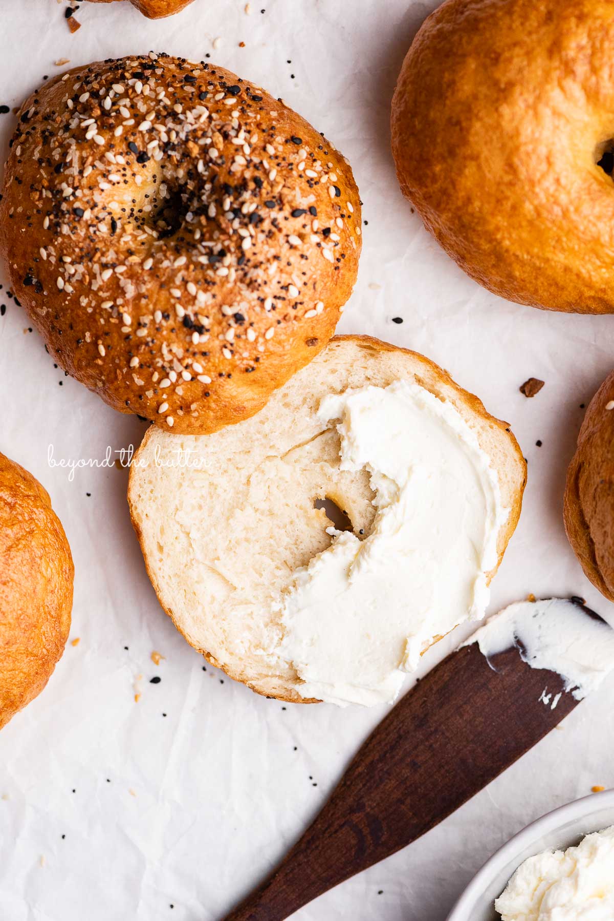 Easy homemade bagel sliced with cream cheese partially spread over the top | © Luyiz®