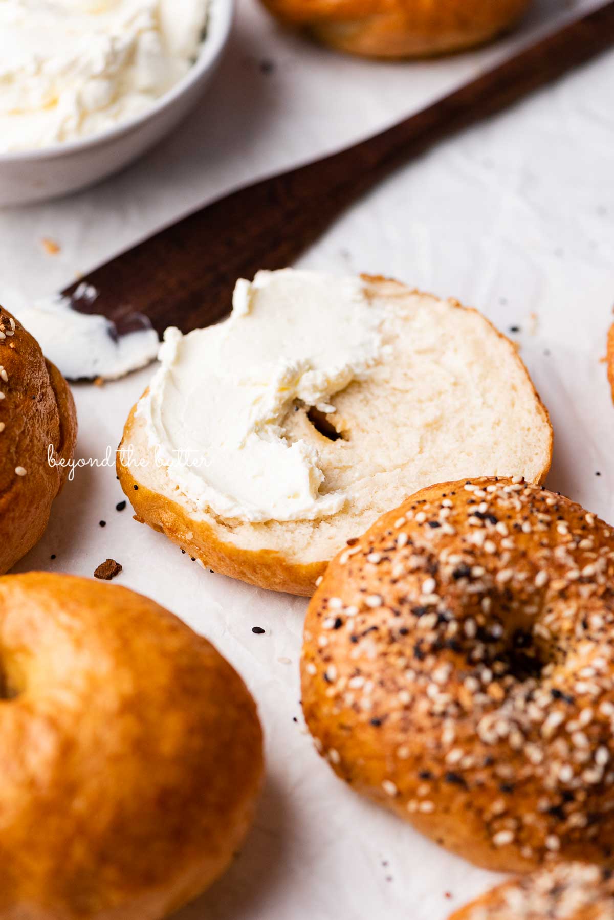 Easy homemade bagel sliced with cream cheese partially spread over the top | © Luyiz®
