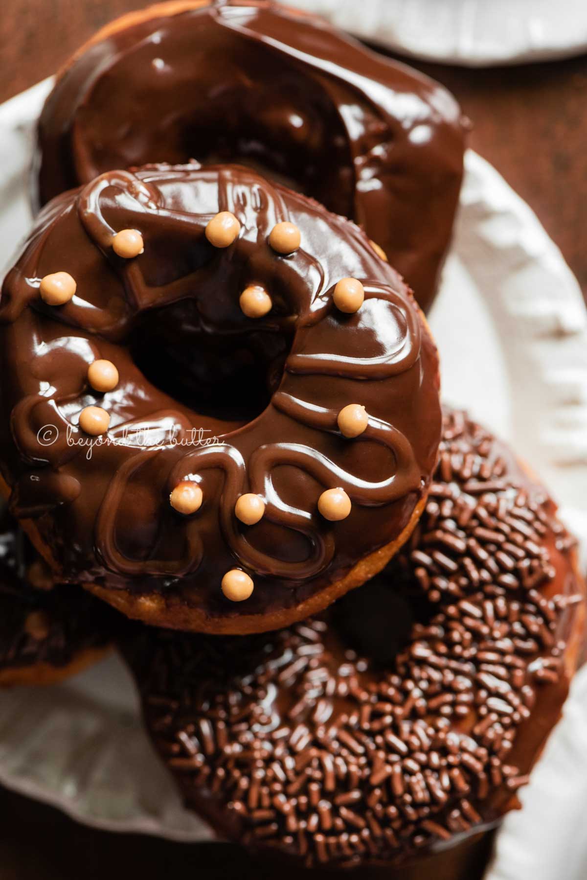 Easy homemade donuts fro scratch topped with chocolate glaze stacked on a dessert plate | All Images © Luyiz™