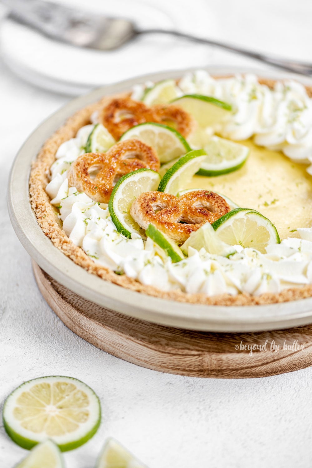 Easy Key Lime Pie decorated with homemade whipped cream, puff pastry twists, and sliced limes | Image and Copyright Policy: © Luyiz, LLC