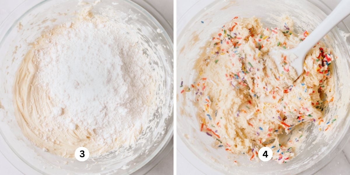 Adding white cake mix and sprinkles to funfetti cookie dough using a white spatula in a large glass mixing bowl on a white background.