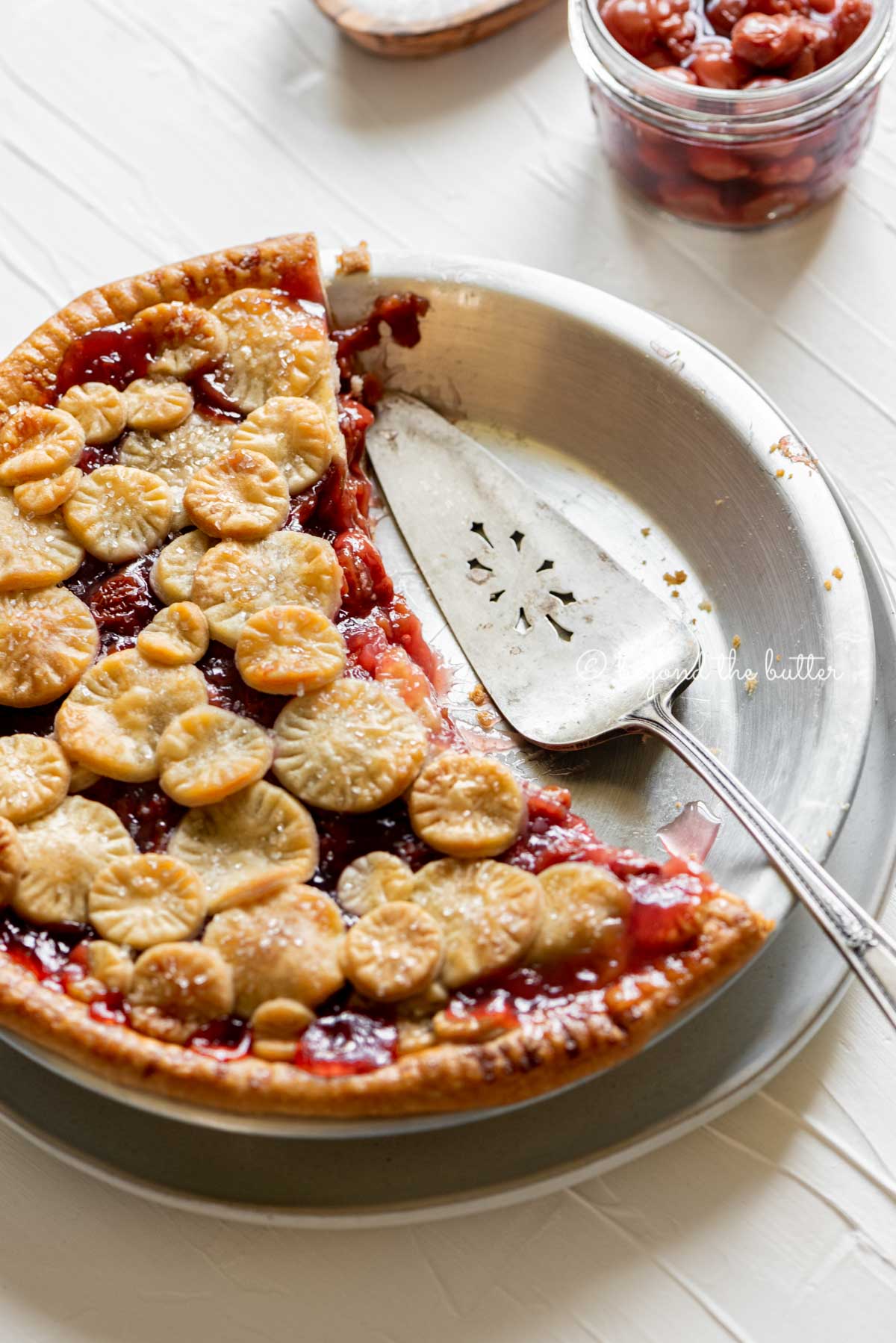 Angled image of half eaten cherry pie with pie server placed on the pie plate | | All Images © Luyiz™