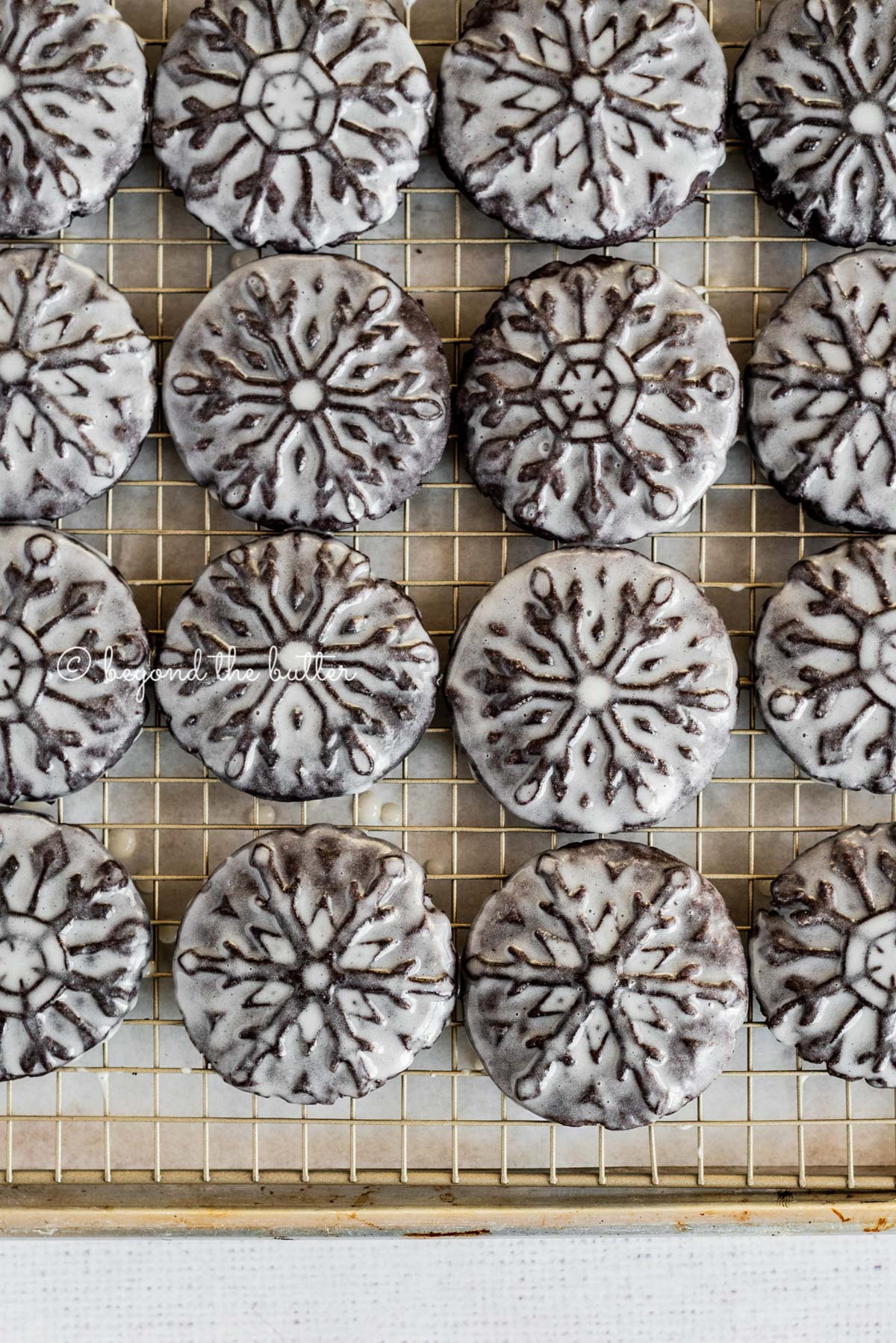 Overhead image of homemade oreo snowflake cookies on a wire cooling rack | All Images © Luyiz®