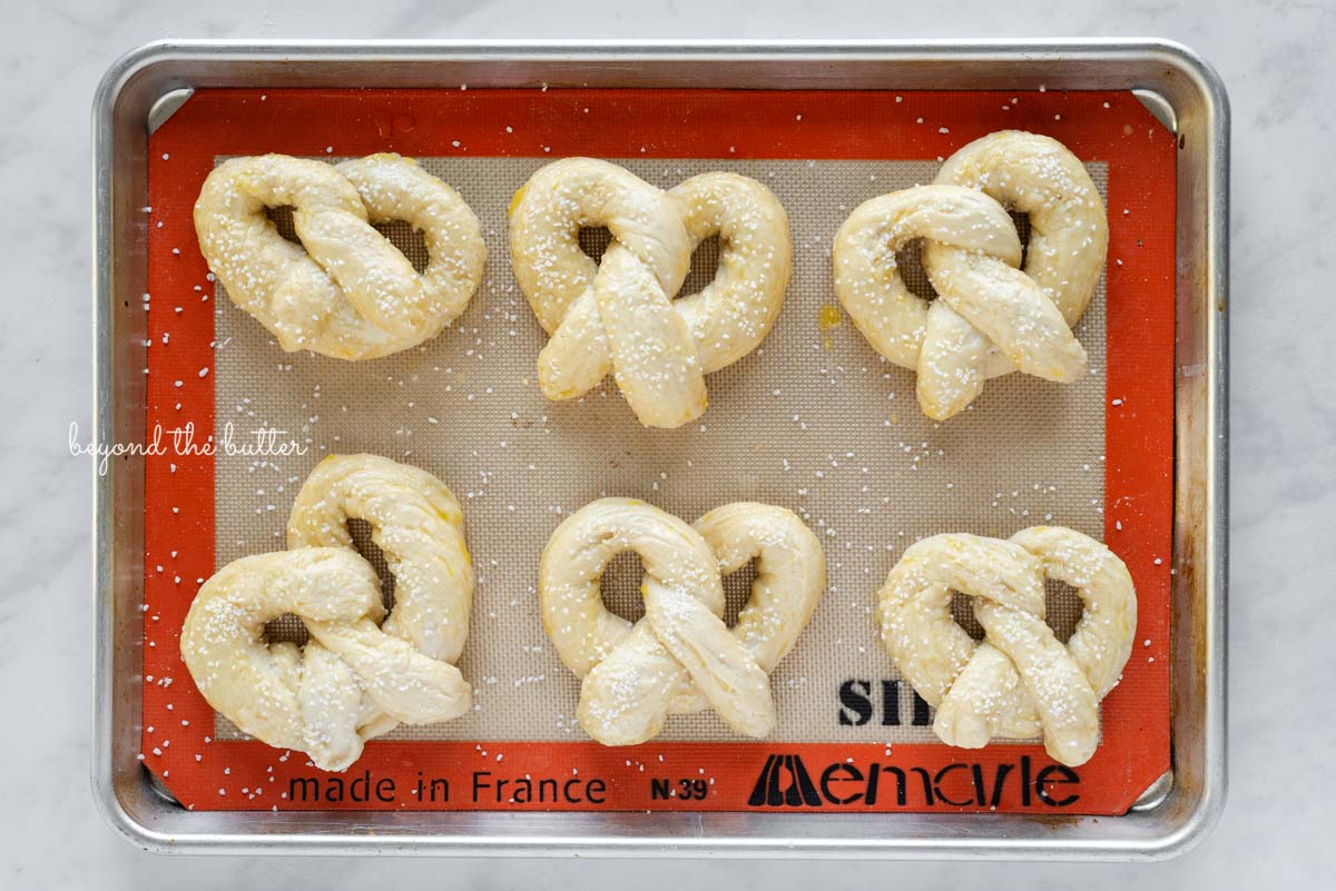 Pre-baked homemade soft pretzels on silione lined baking sheet from Luyiz | © Luyiz®