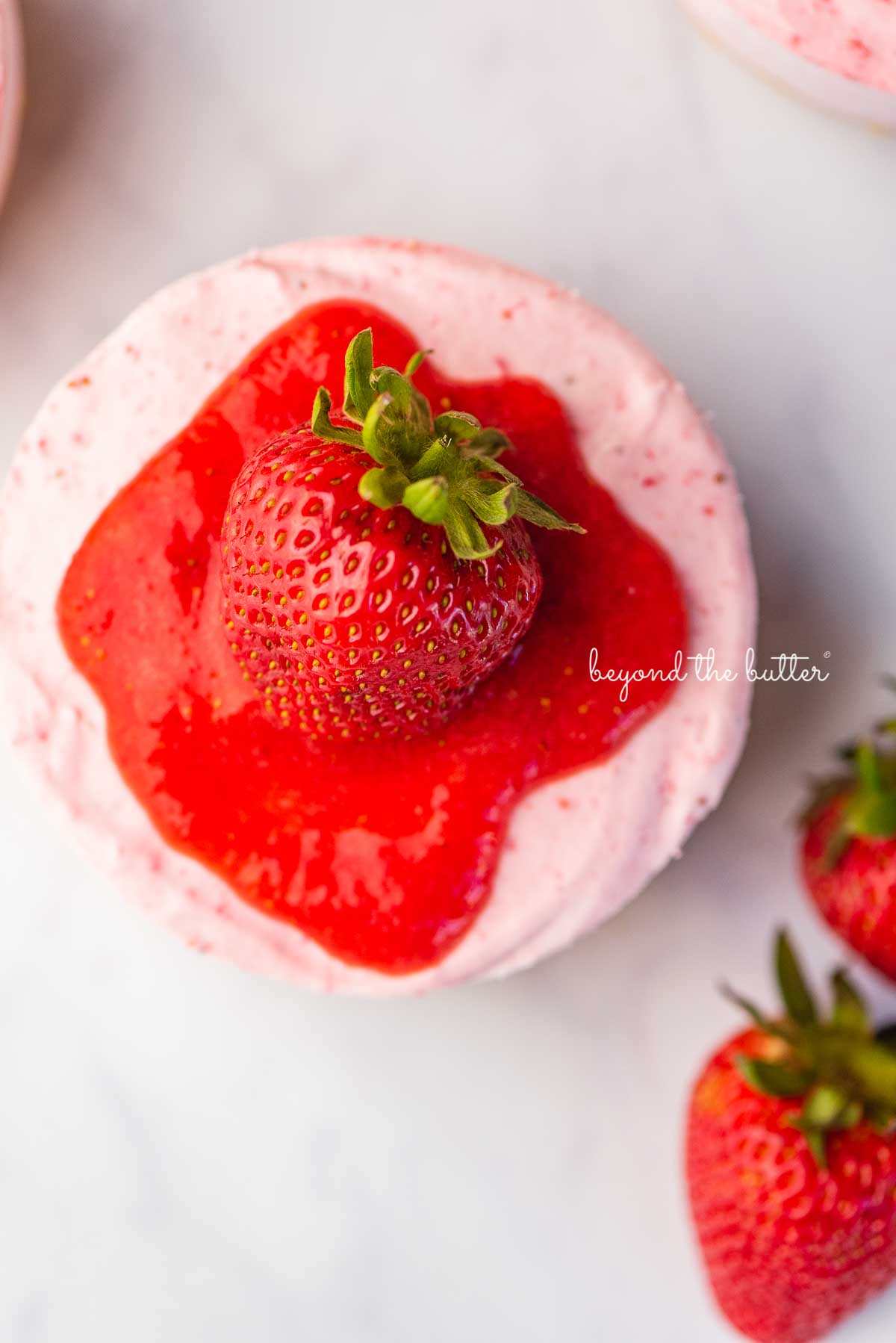 Sliced small 4-inch no-bake strawberry cheesecake on a marbled background | © Luyiz®