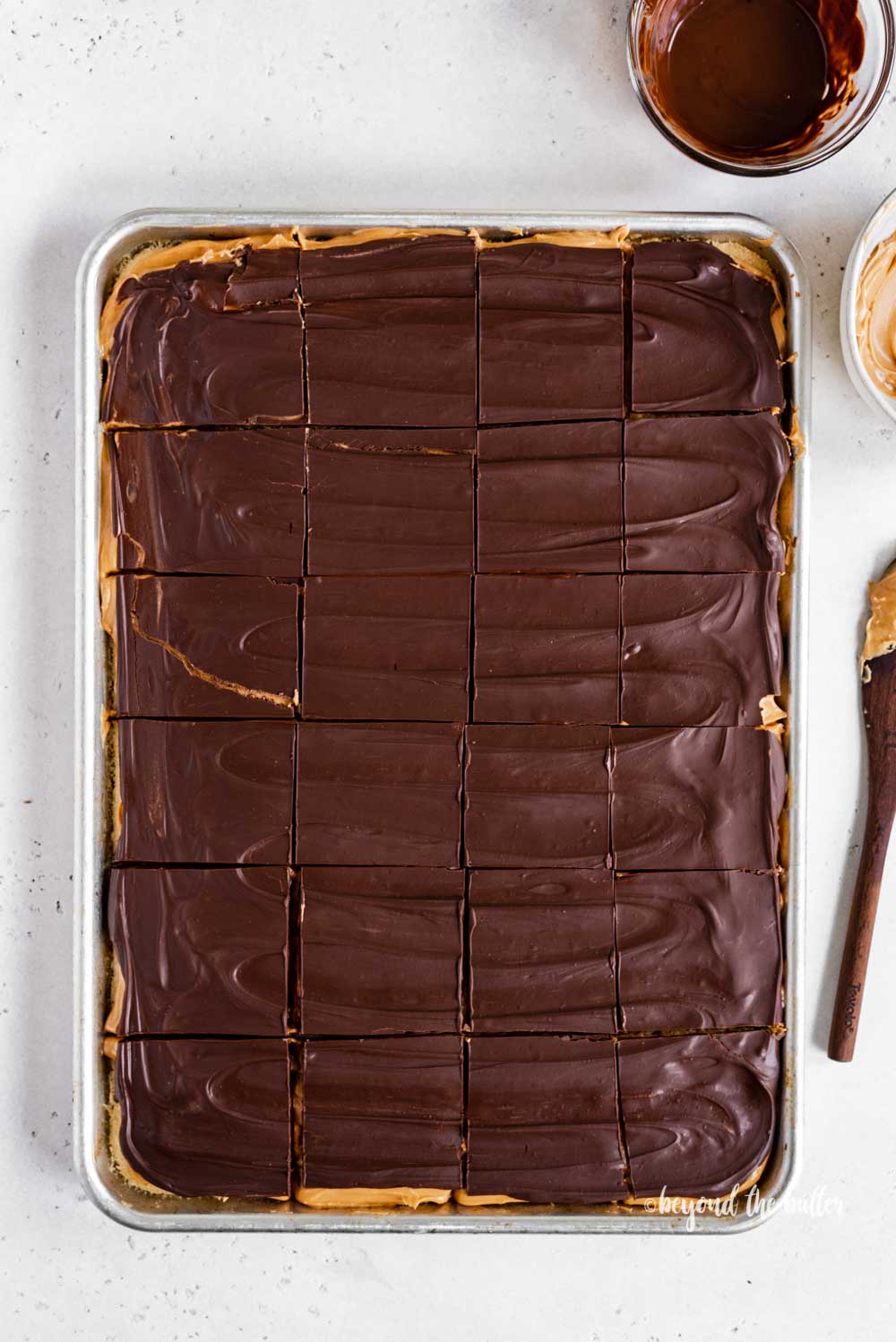 Overhead image of cut peanut butter kandy kakes with bowls of chocolate and peanut butter next to the tray | All Images © Luyiz™