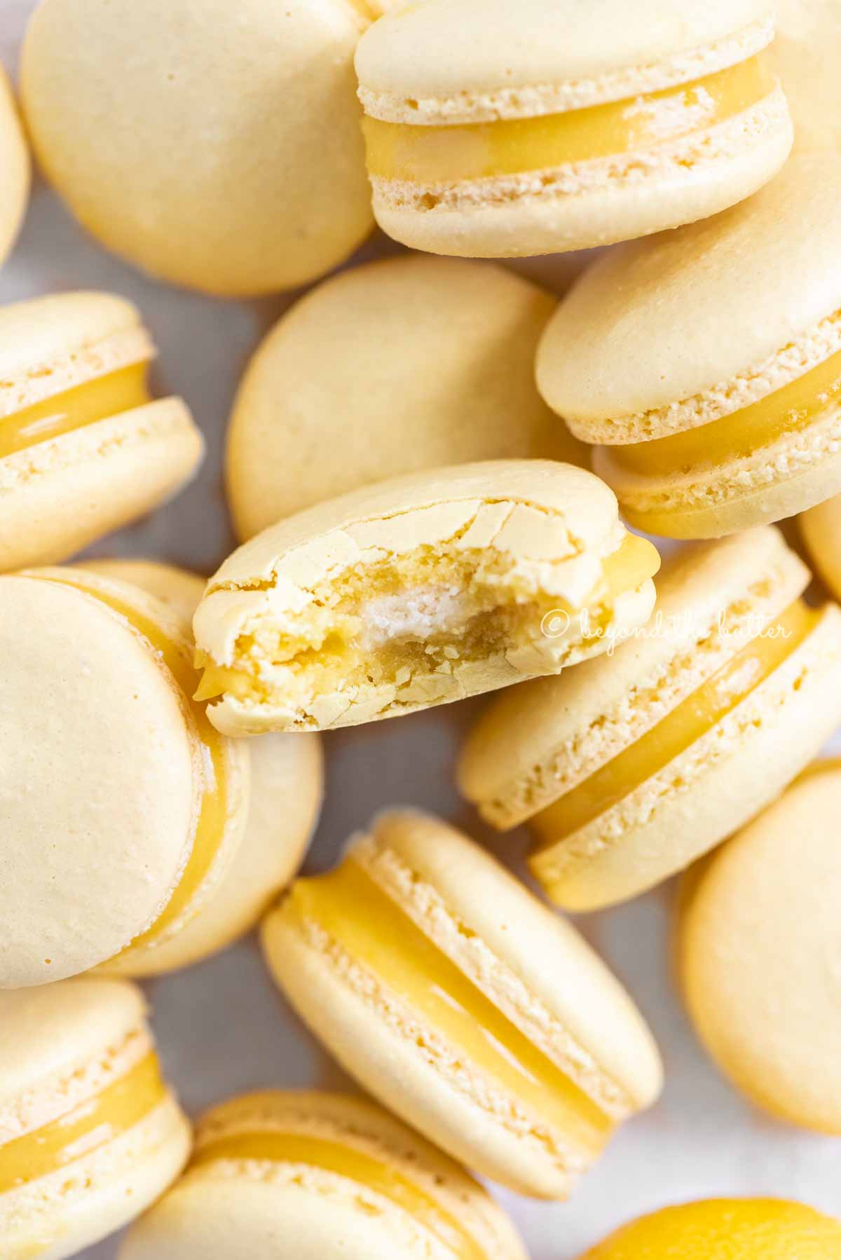 Randomly placed lemon macarons with a bite taken out of the center macaron | All Images © Luyiz™