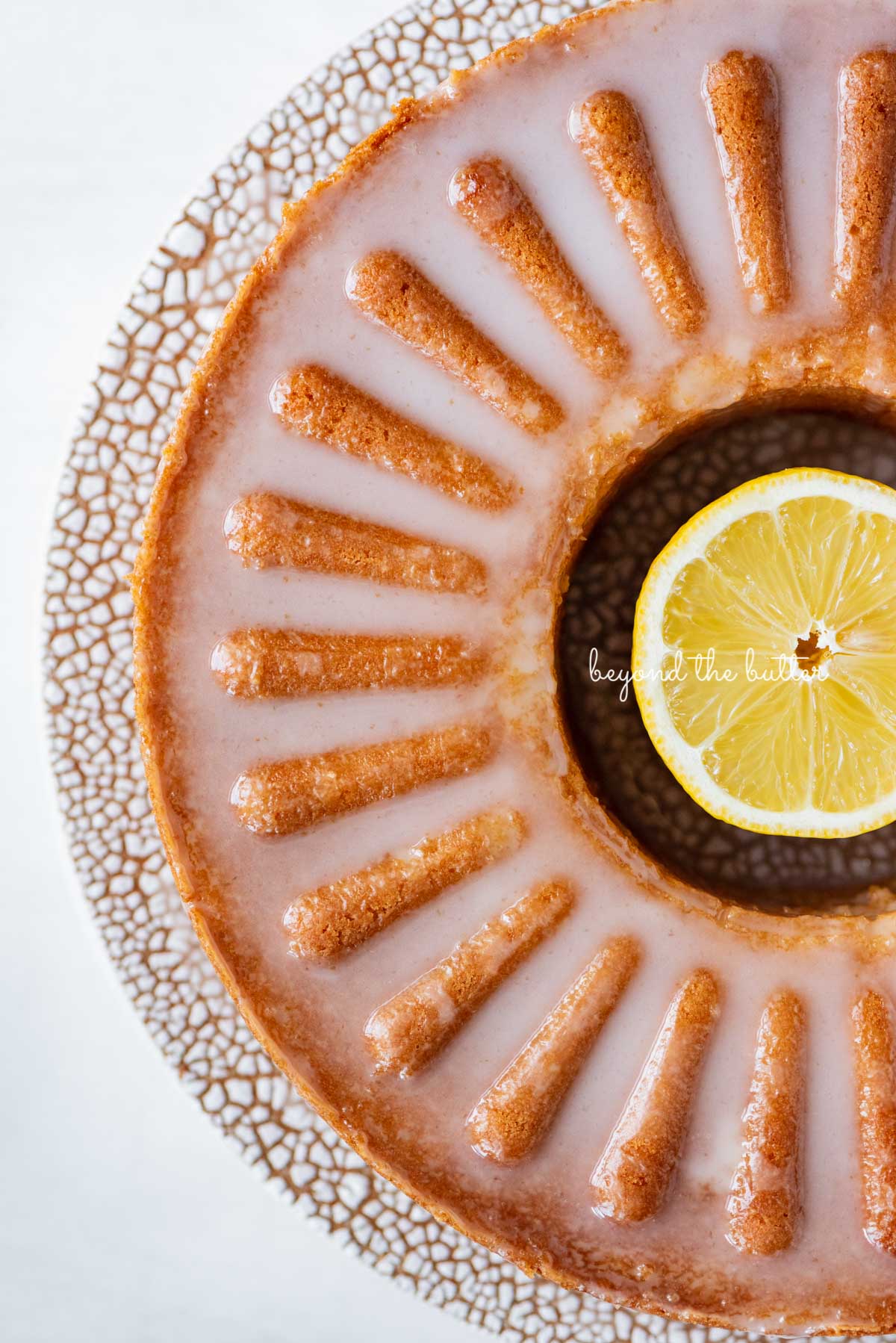 Glazed lemon cream cheese pound cake on a ceramic cake stand from Sweetheart Ceramics | © Luyiz®