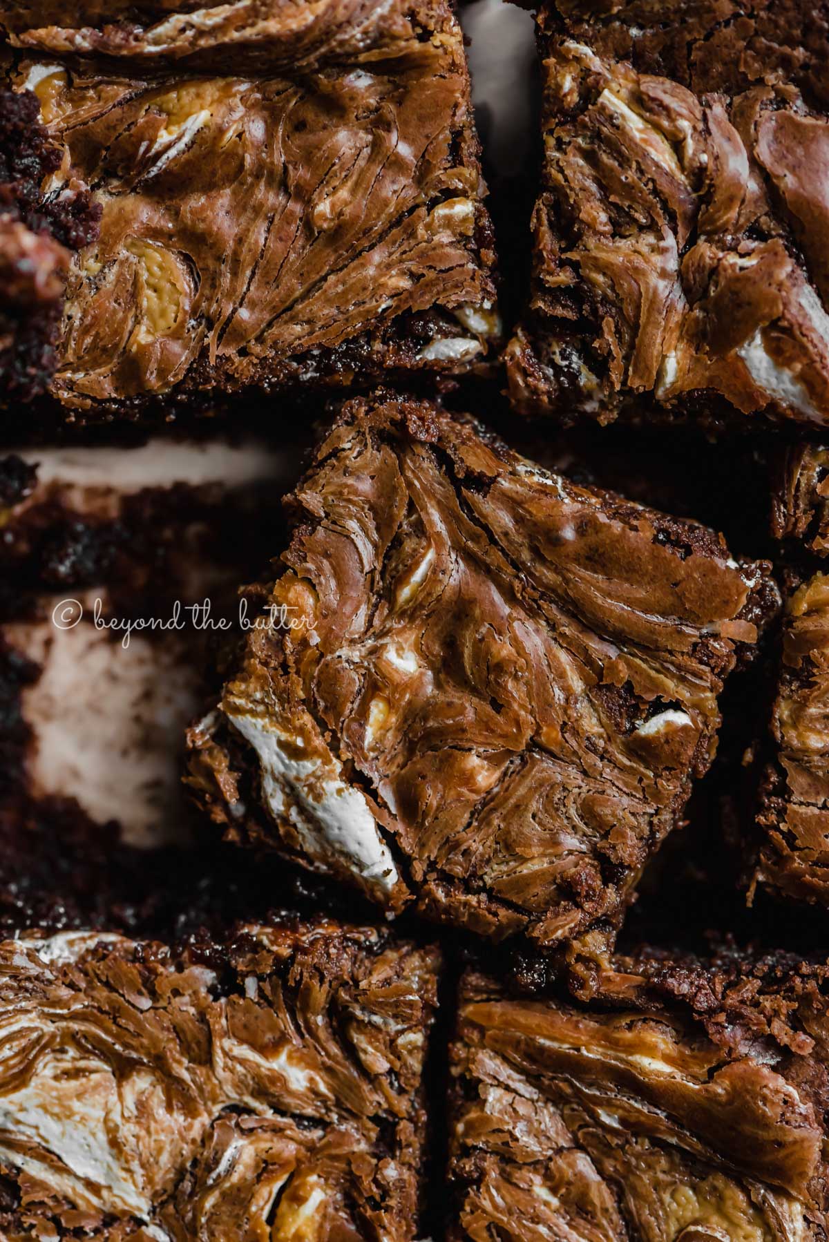 Closeup of randomly placed marshmallow peanut butter brownies on parchment paper | All Images © Luyiz™
