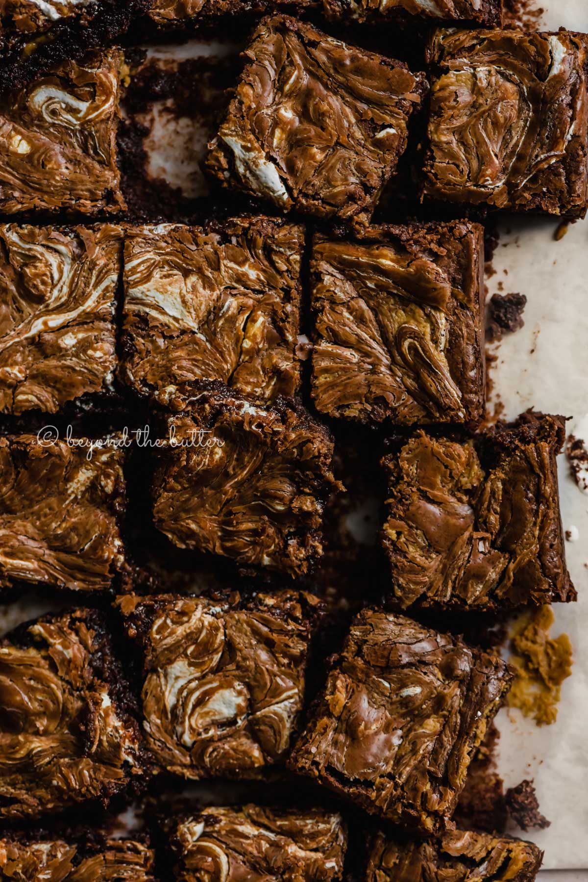 Randomly arranged marshmallow peanut butter brownies on parchment paper | All Images © Luyiz™