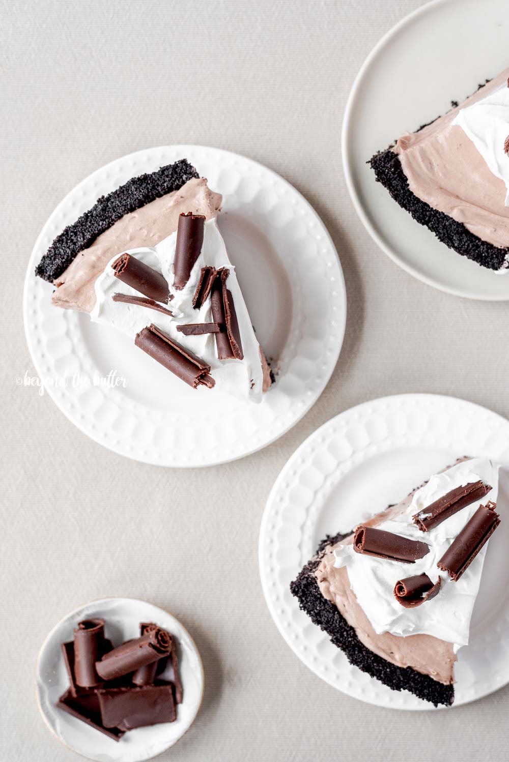 Slices of no-bake chocolate cream pie with chocolate wafer crust on dessert plates | All Images © Luyiz™