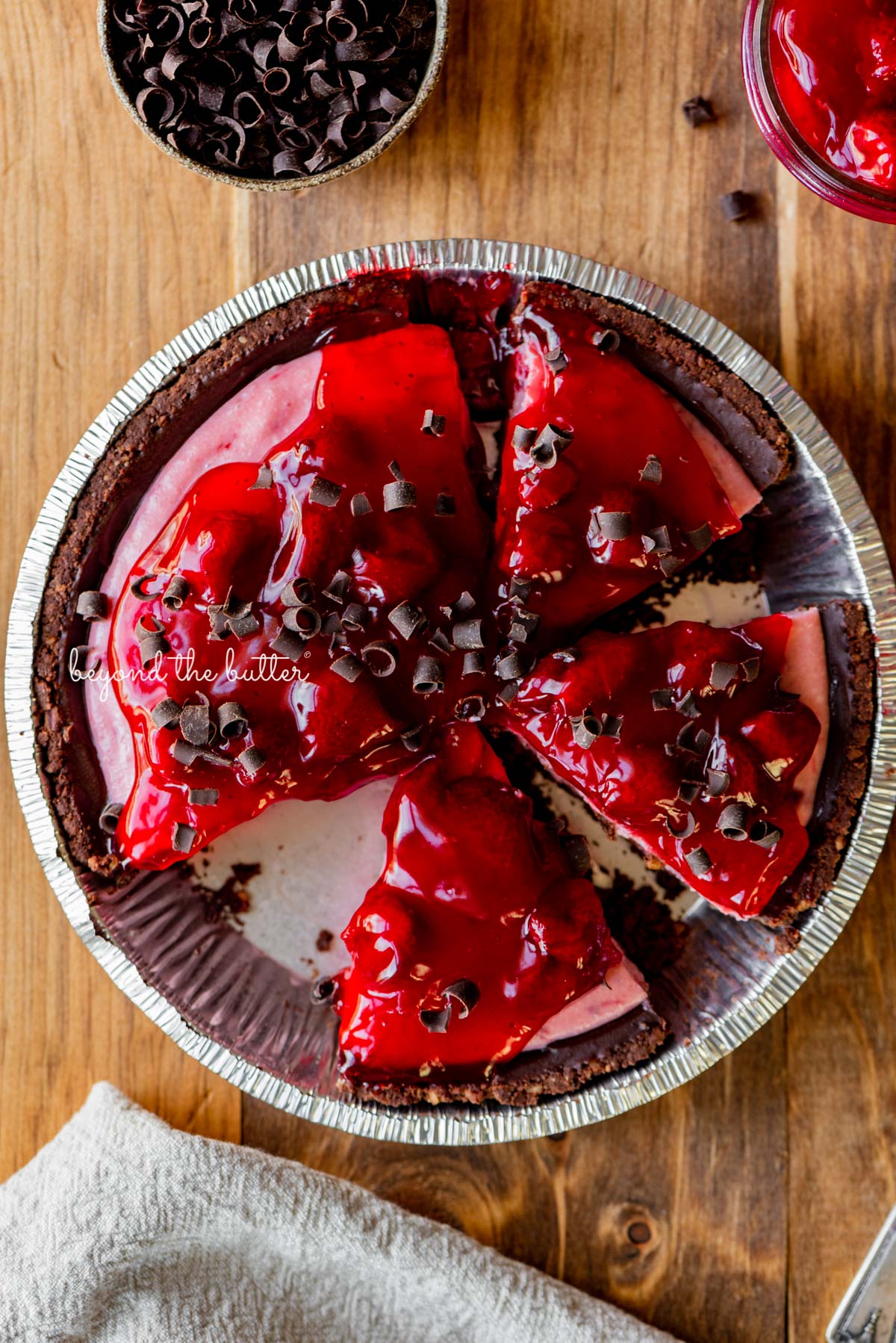 No bake strawberry chocolate pie with small bowl of chocolate curls and extra strawberry pie filling on wood table | All images © Luyiz®