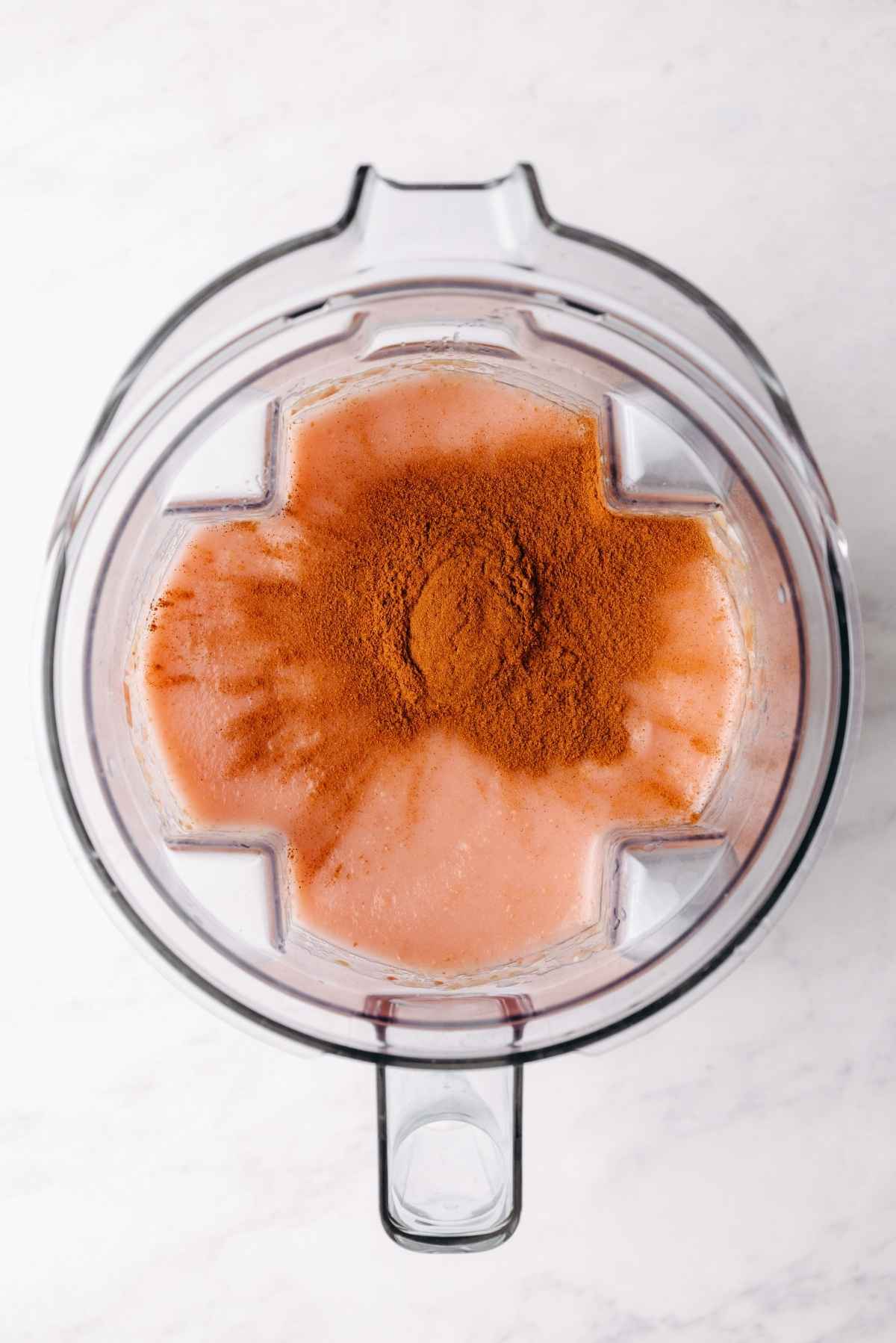 Ground cinnamon added to the top of the applesauce in the blender.