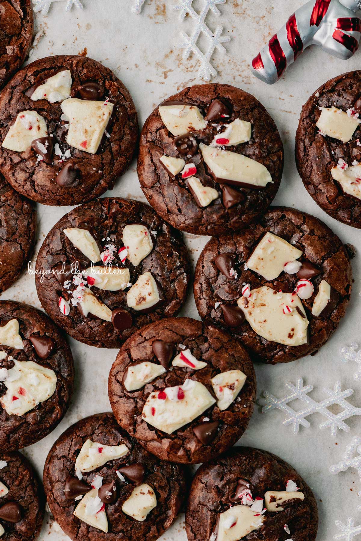 Just baked peppermint bark brownie crinkle cookies on a parchment paper lined baking sheet | © Beyond the Buter®