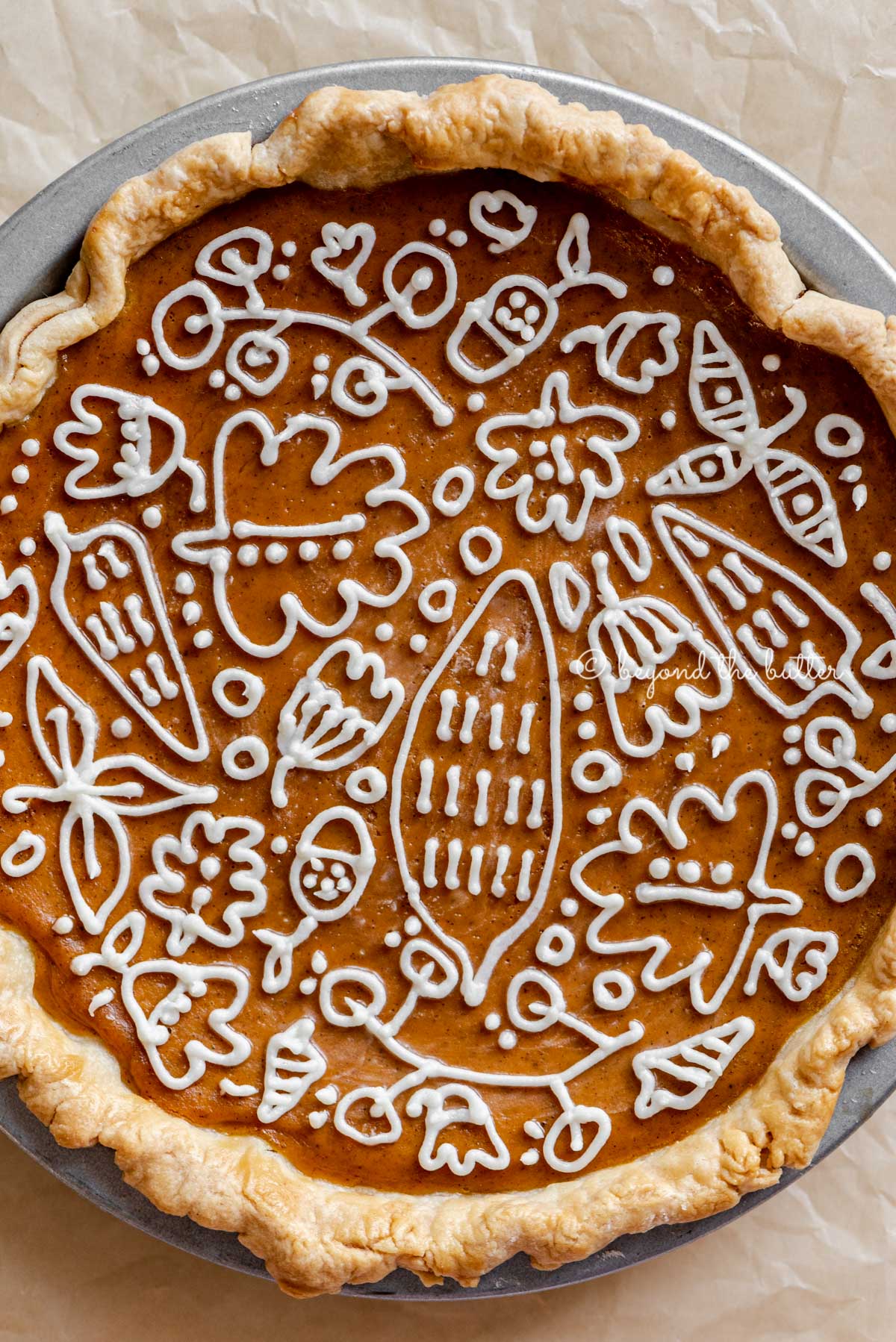 Overhead close up image of perfect pumpkin pie with cream cheese frosting piped decorative top | All Images © Luyiz™