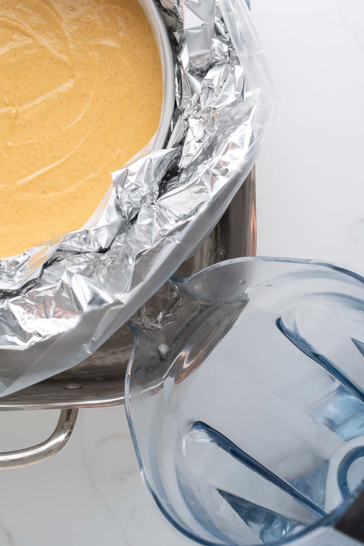 Filling a roasting pan with hot water for a water bath to bake the cheesecake.
