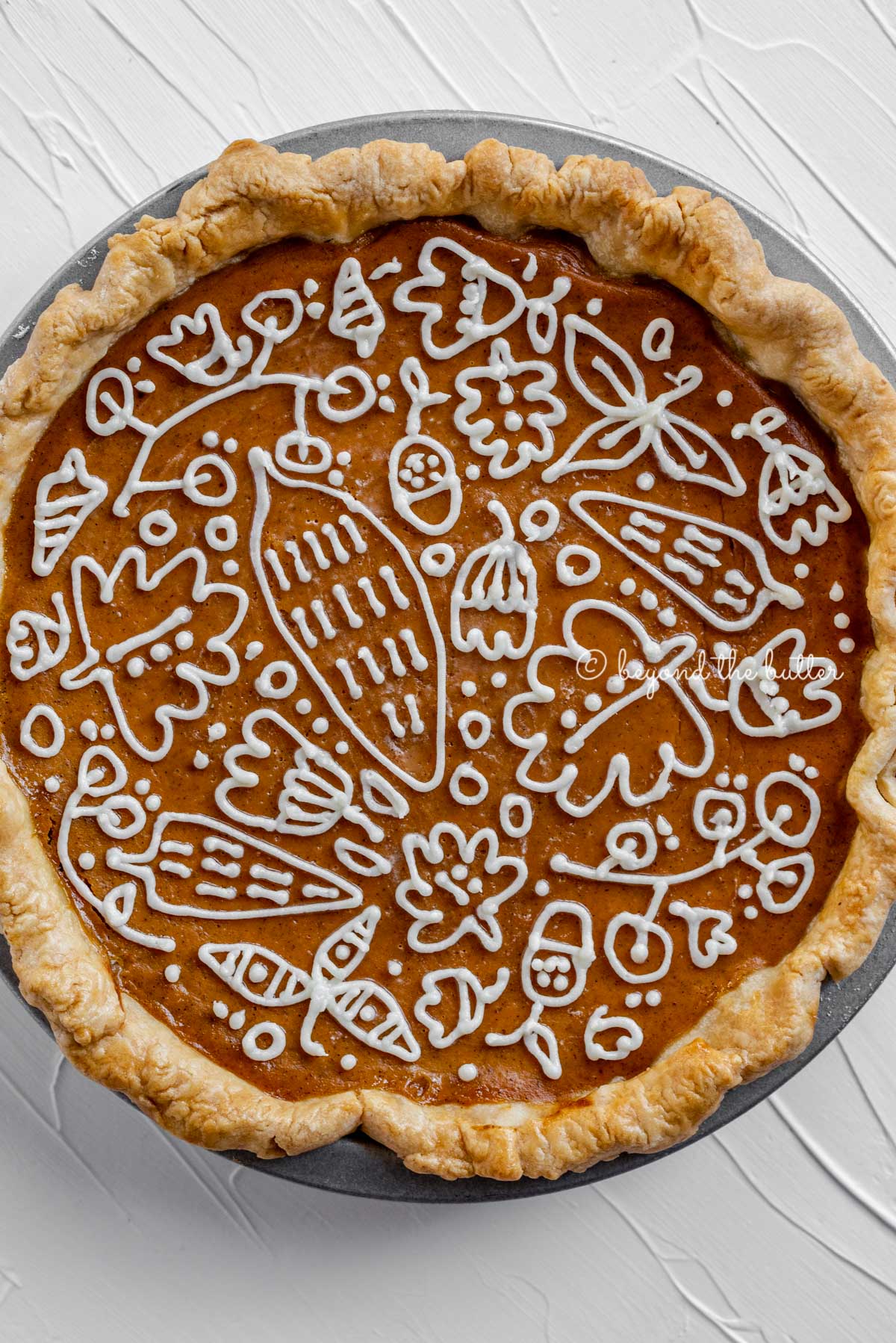 Overhead image of pumpkin pie with a piped cream cheese frosting decoration | All images © Luyiz™