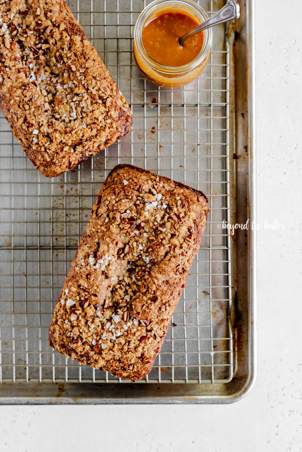 Overhead image of 2 loaves of banana nut bread on a wire cooling rack | All Images © Luyiz™