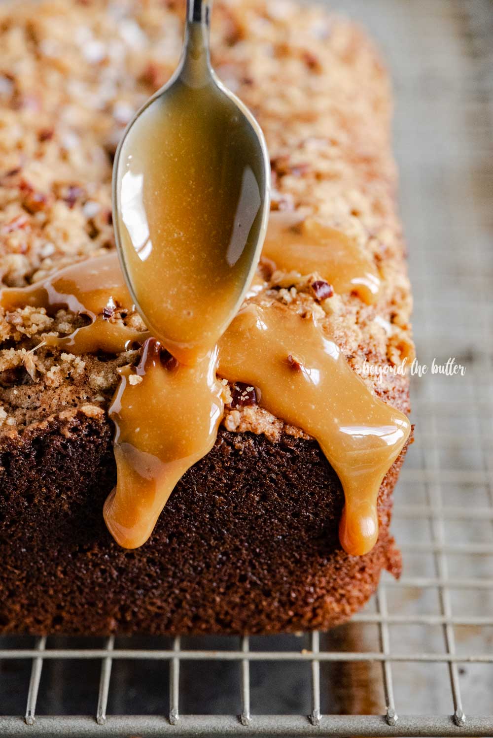 Angled image of salted caramel banana nut bread loaves on a wire cooling rack with caramel drizzled over the top | All Images © Luyiz™