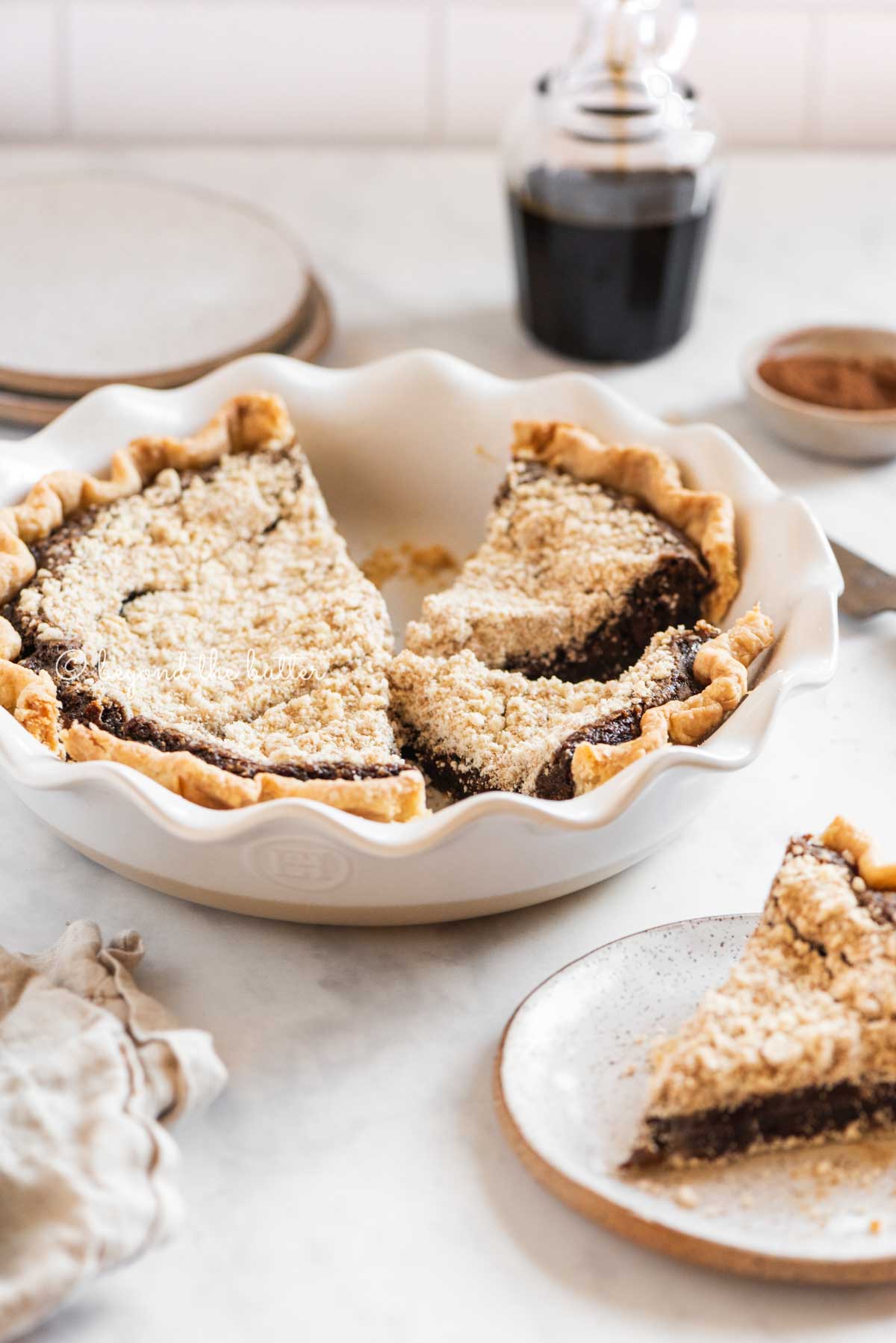 Pie plate with slices of pennsylvania dutch shoo fly pir removed and set on dessert plates with glass of molasses in the background | All Images © Luyiz™