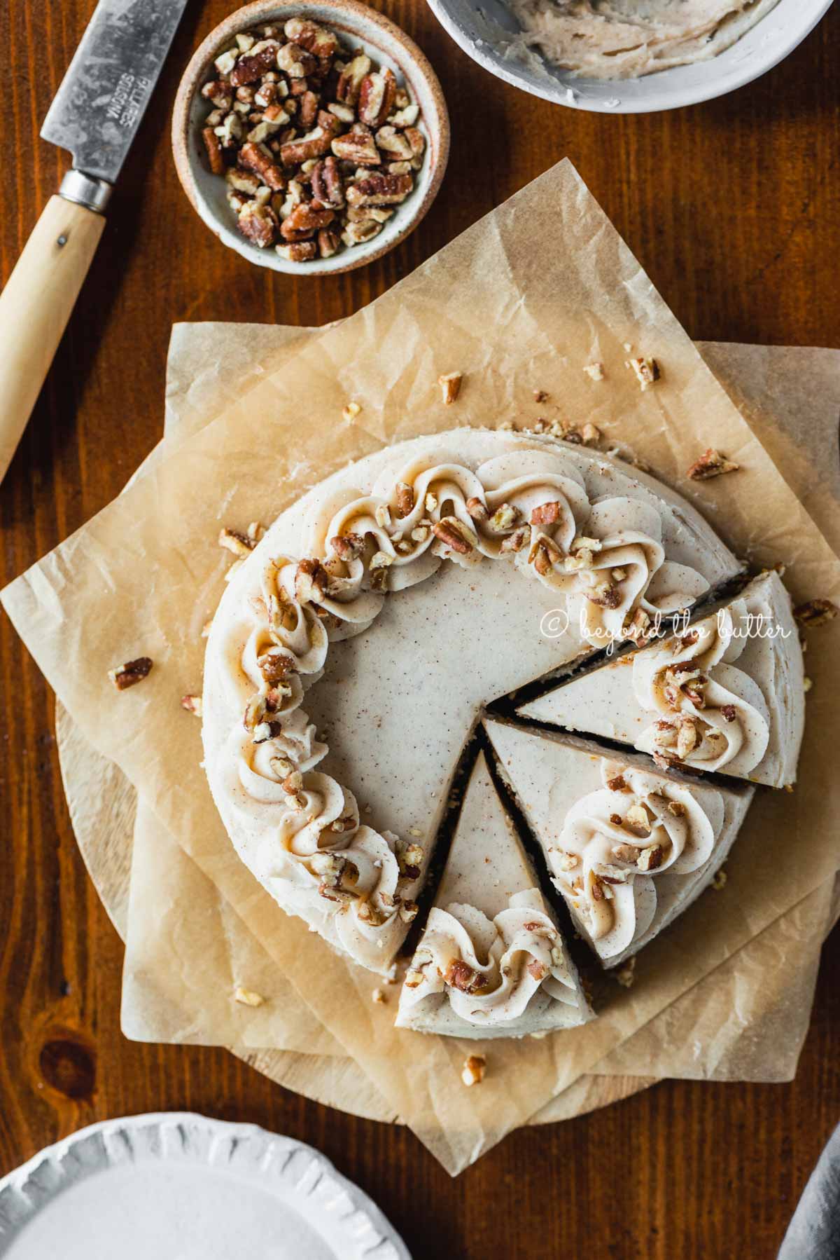 Overhead image of sliced 6 inch single layer carrot cake on parchment paper | All Images © Luyiz®