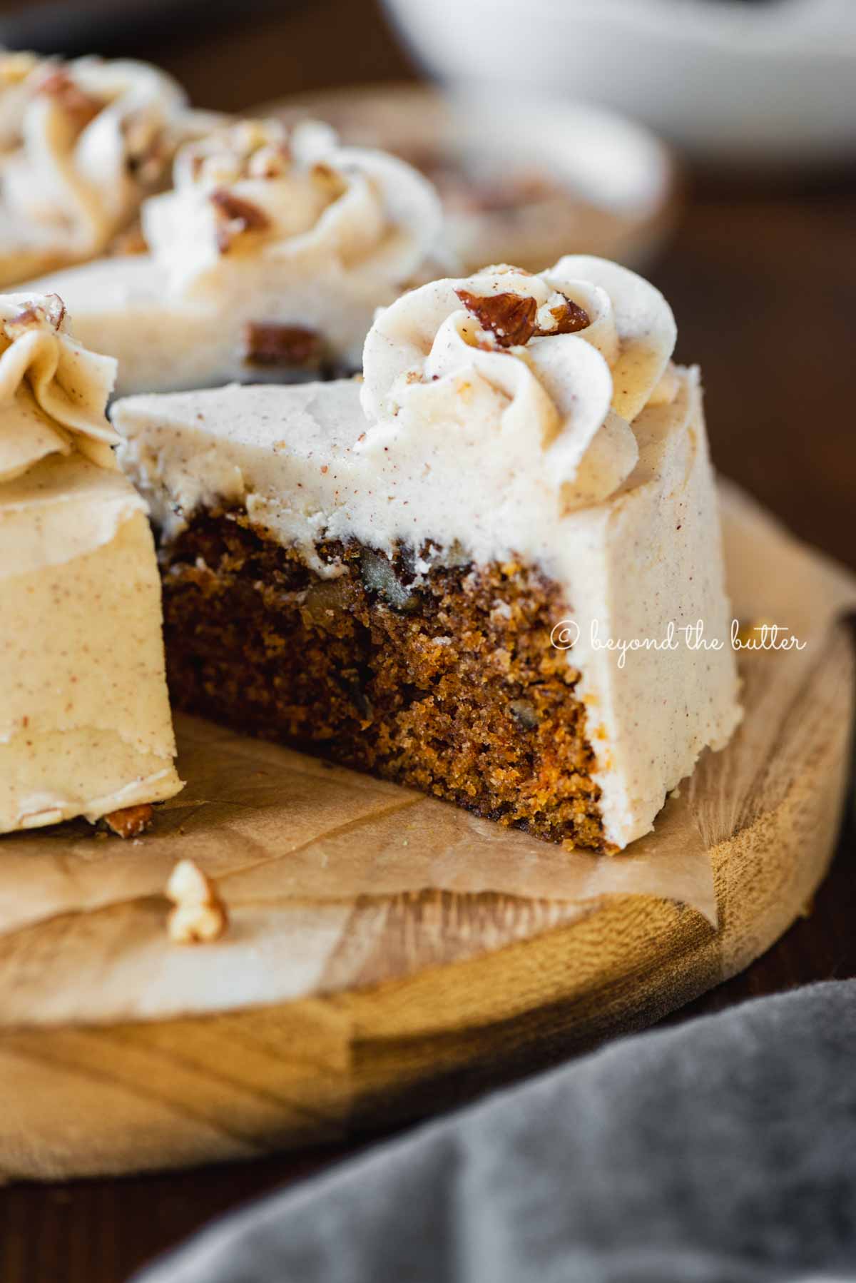 Angled closeup image of sliced 6 inch single layer carrot cake on parchment paper | All Images © Luyiz®