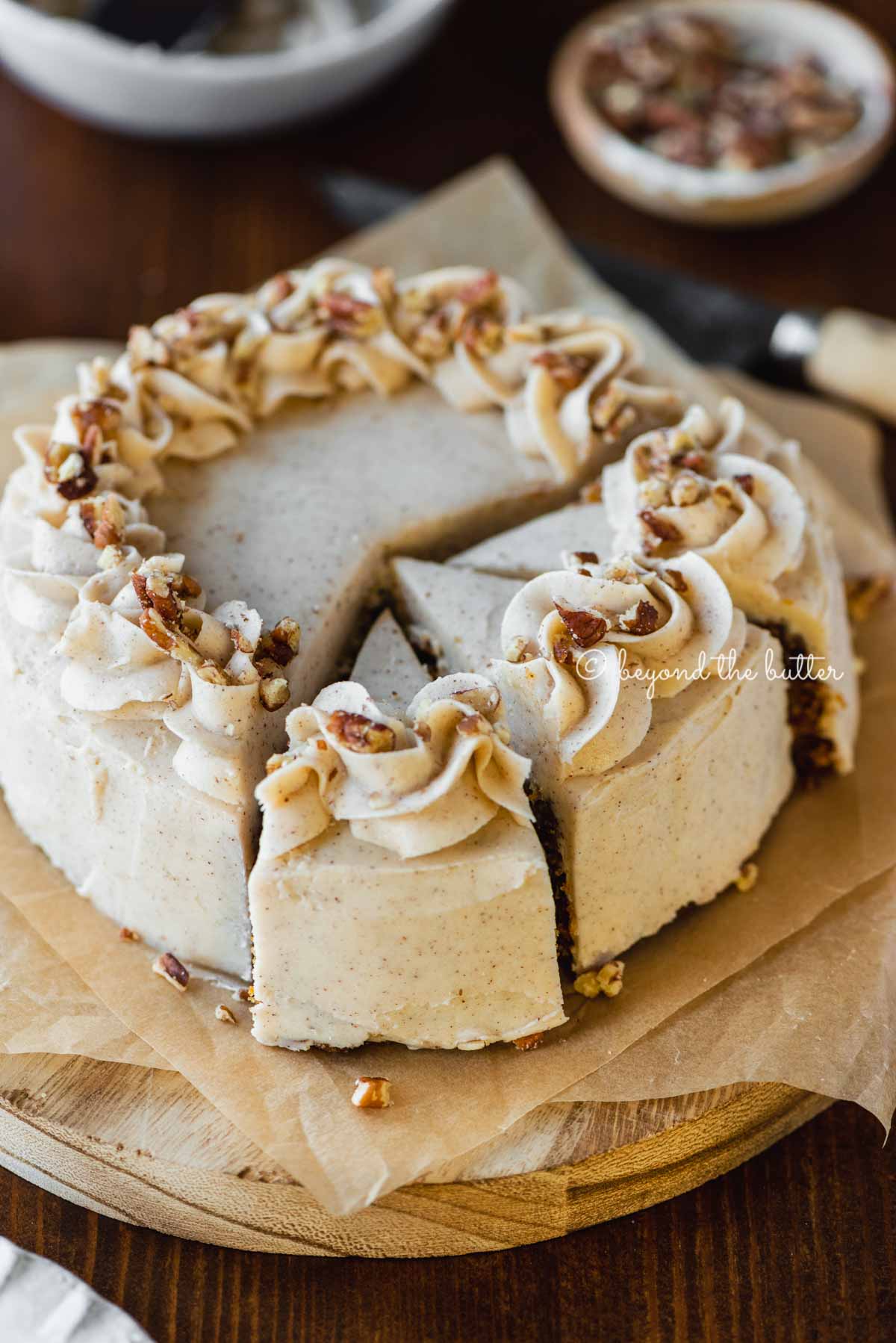 Angled overhead image of sliced 6 inch single layer carrot cake on parchment paper | All Images © Luyiz®