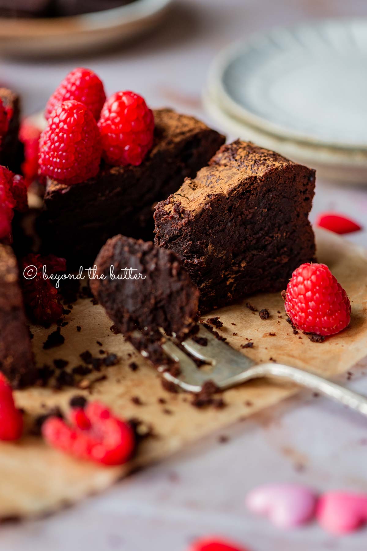 Partially eaten small flourless chocolate cake with fork on parchment paper | All images © Luyiz®