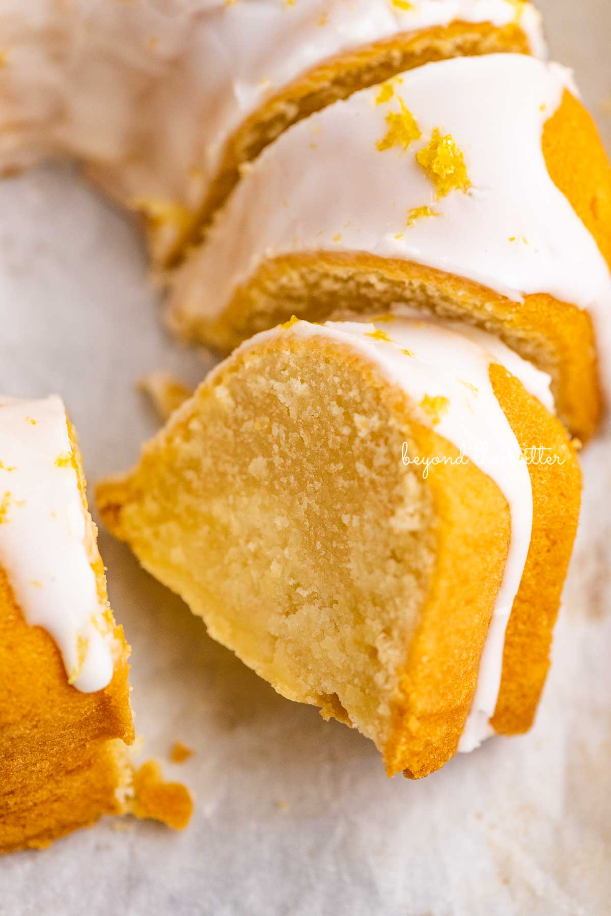 Sliced lemon cream cheese pound cake on white parchment paper | © Luyiz®